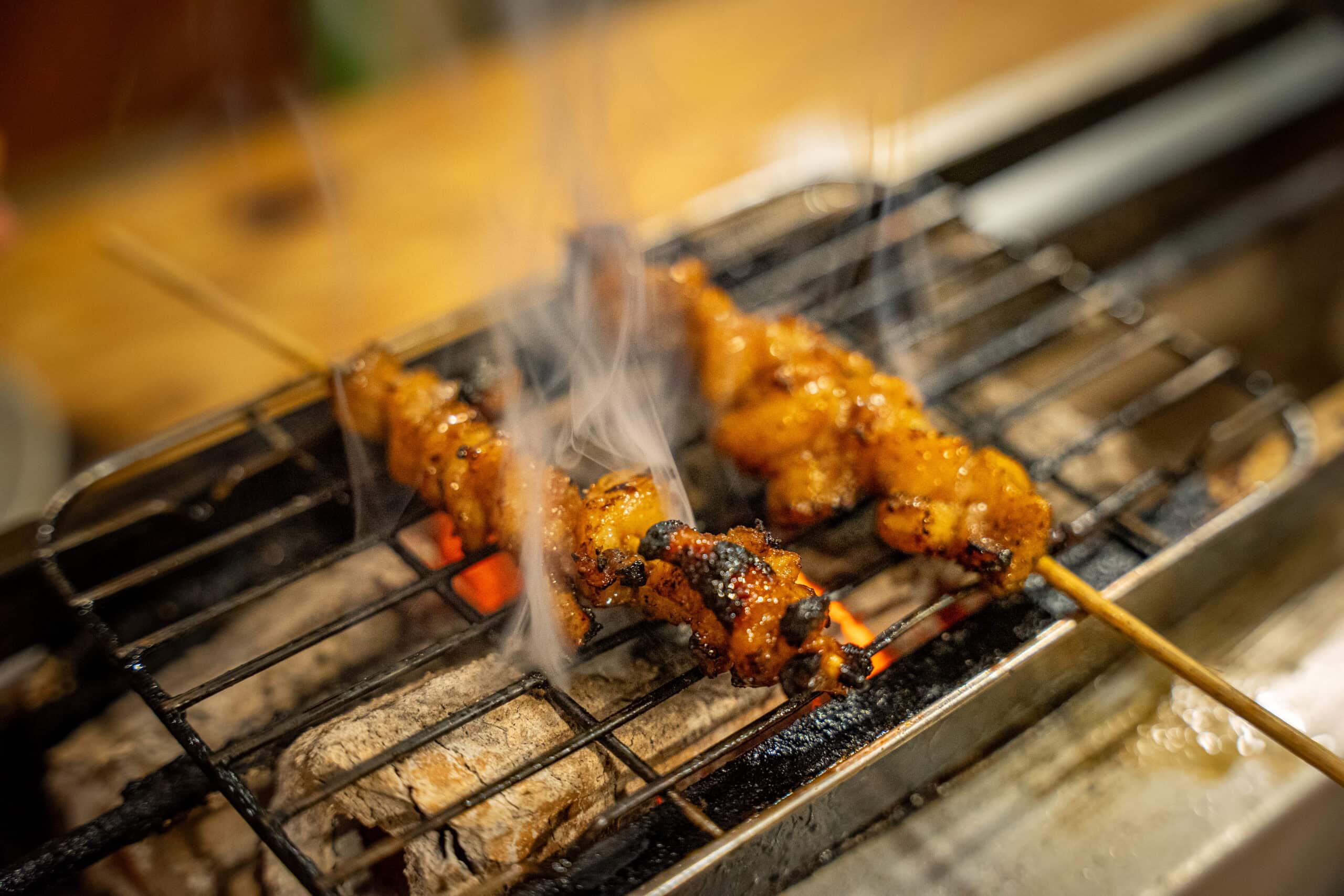 Chicken skewers grilling on the coals