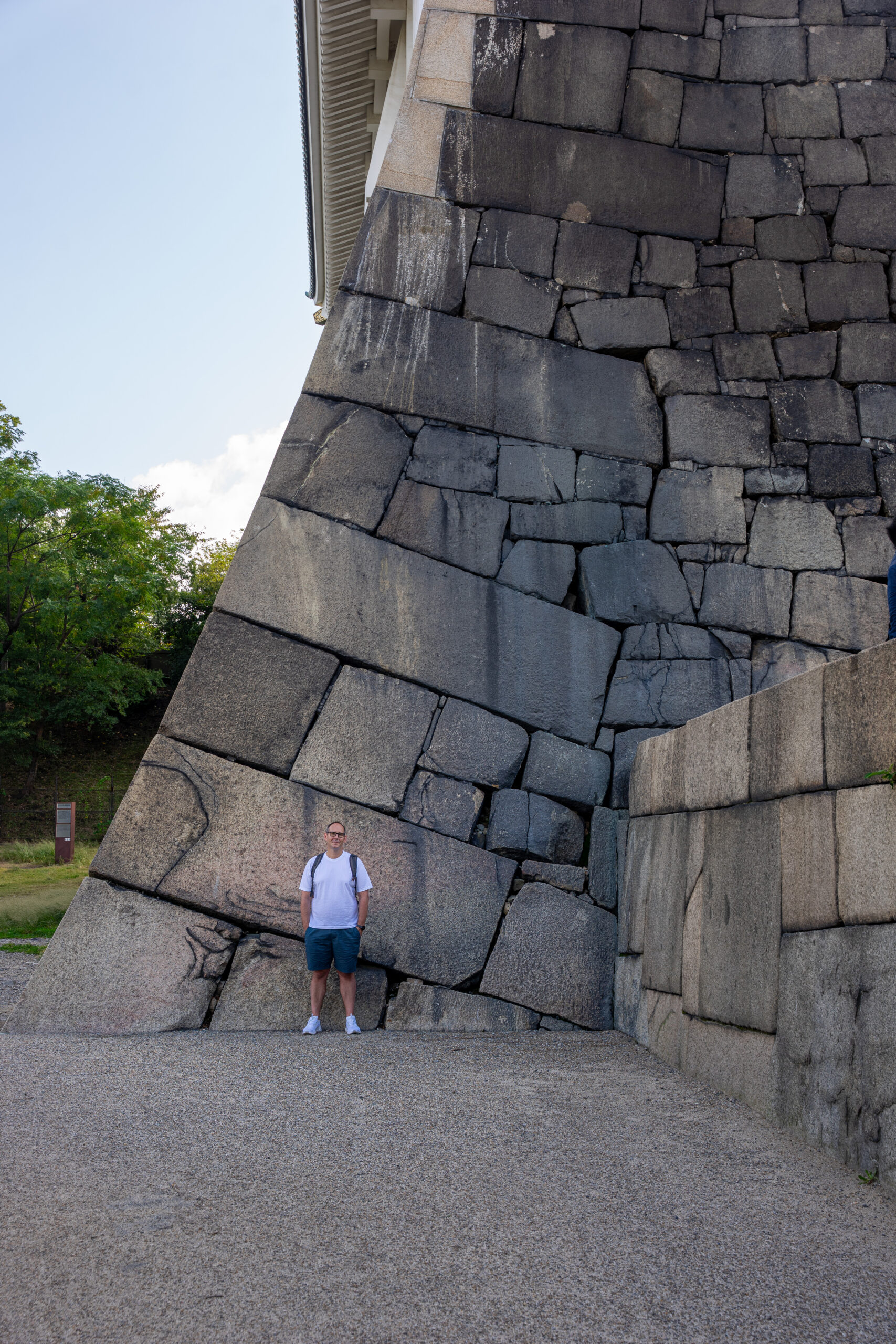 I am standing in front of large stones in the walls at Osaka Castle