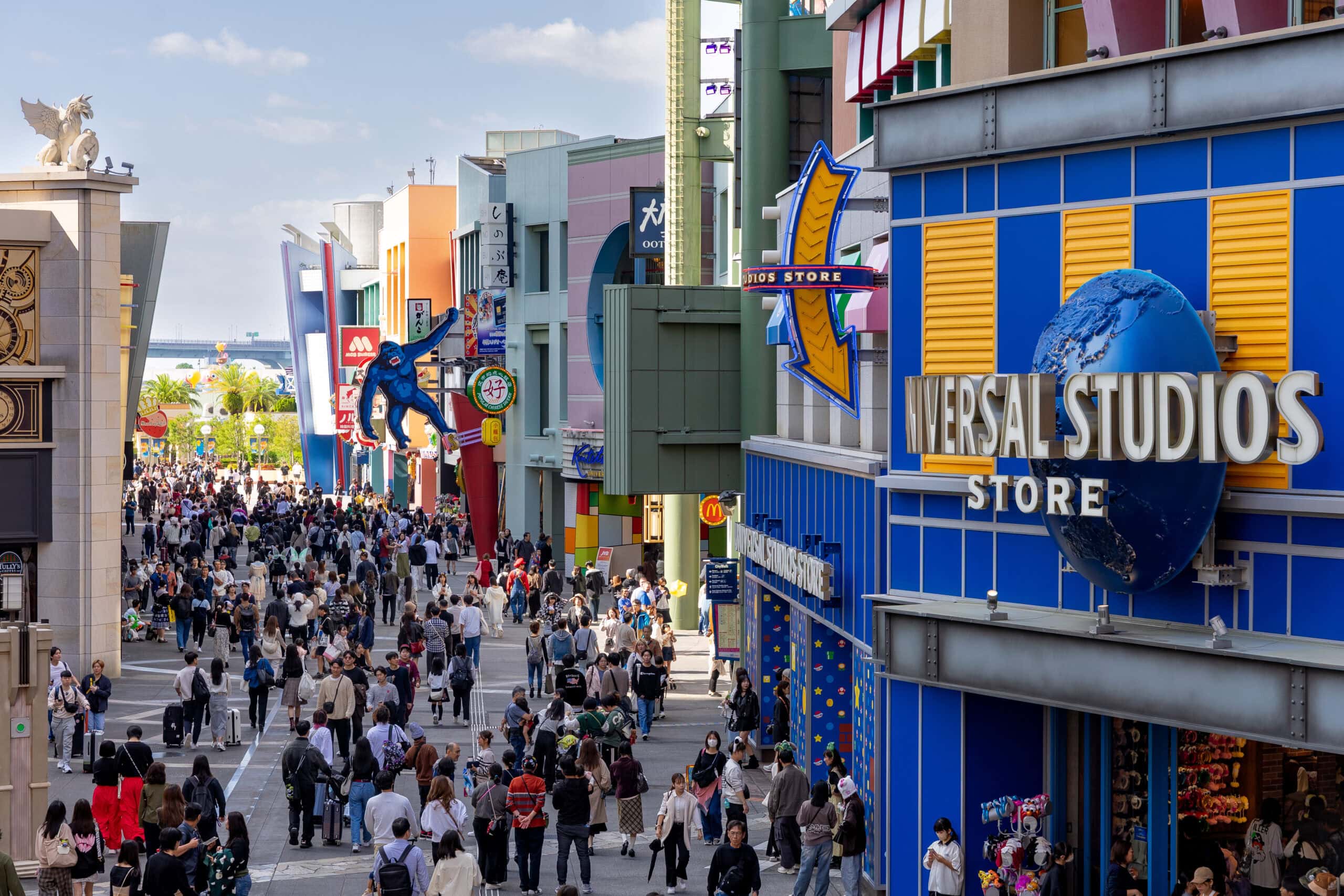 Crowds walk toward the entrance of Universal Studios in Osaka.