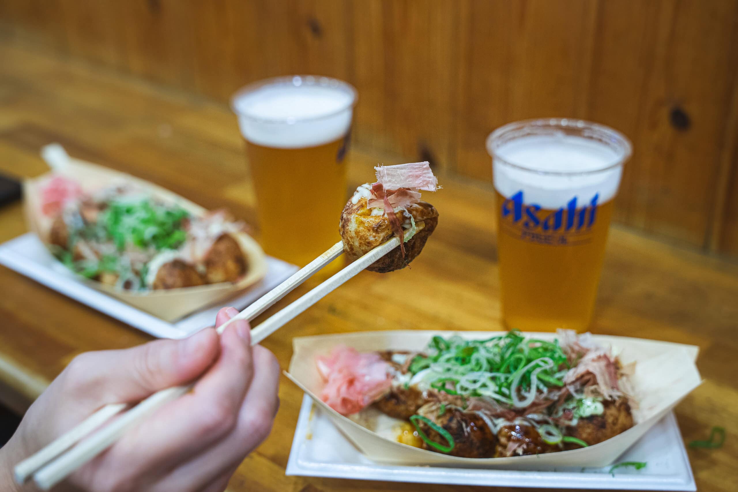Takoyaki and two plastic cups of Asahi beer we had for dinner in Dotonburi on our two day Osaka itinerary