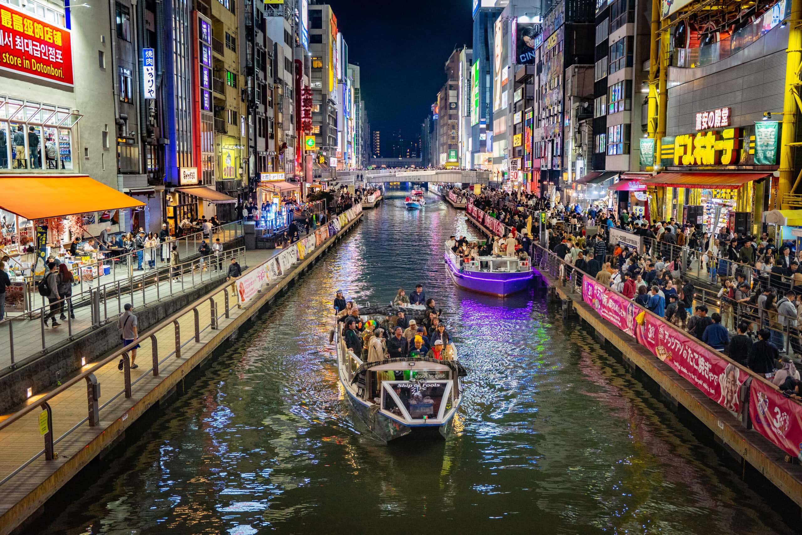Toursit take a cruise along the canal in Dotonburi at night