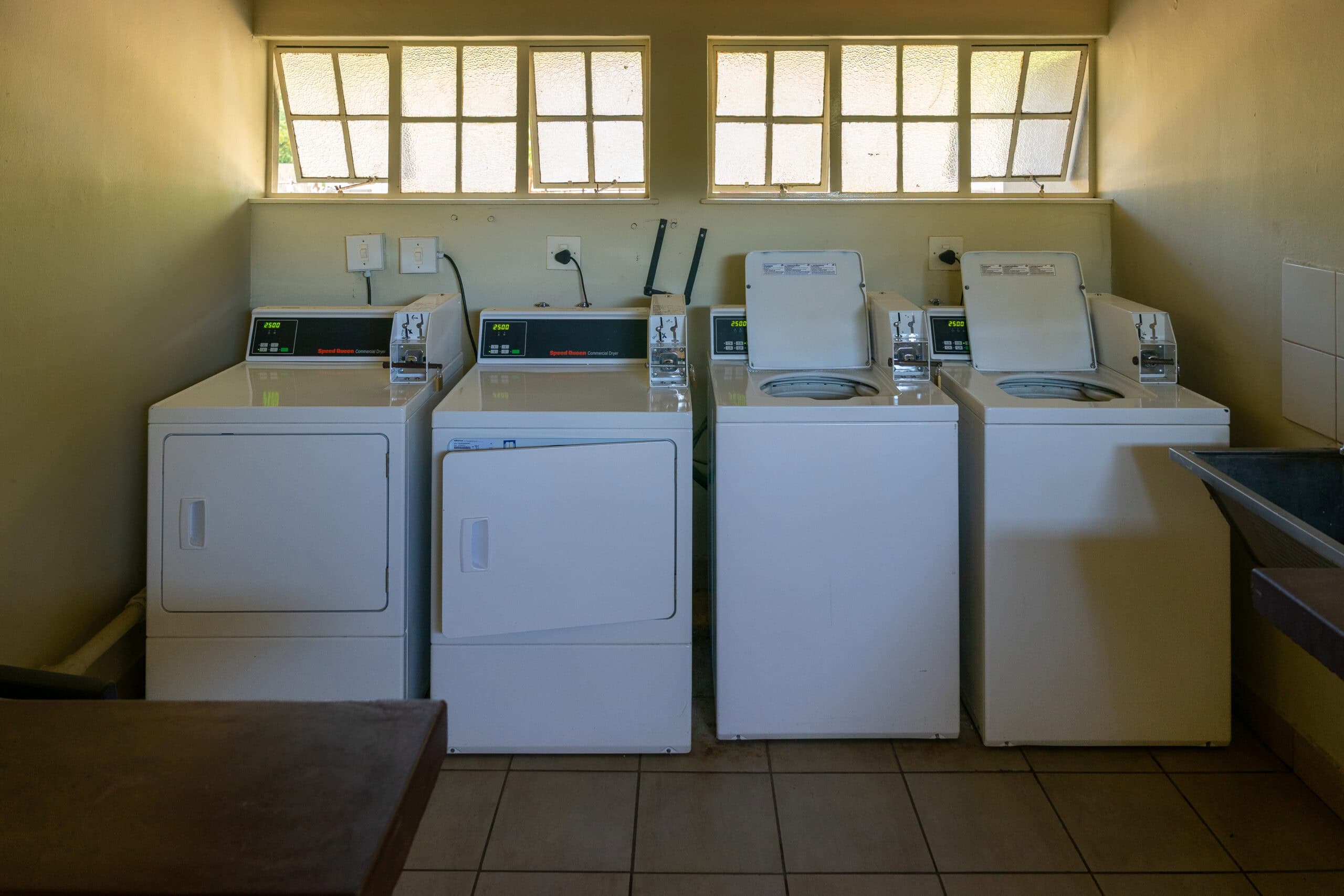tow top loader washing machines and two dryers at the Shingwedzi laundry