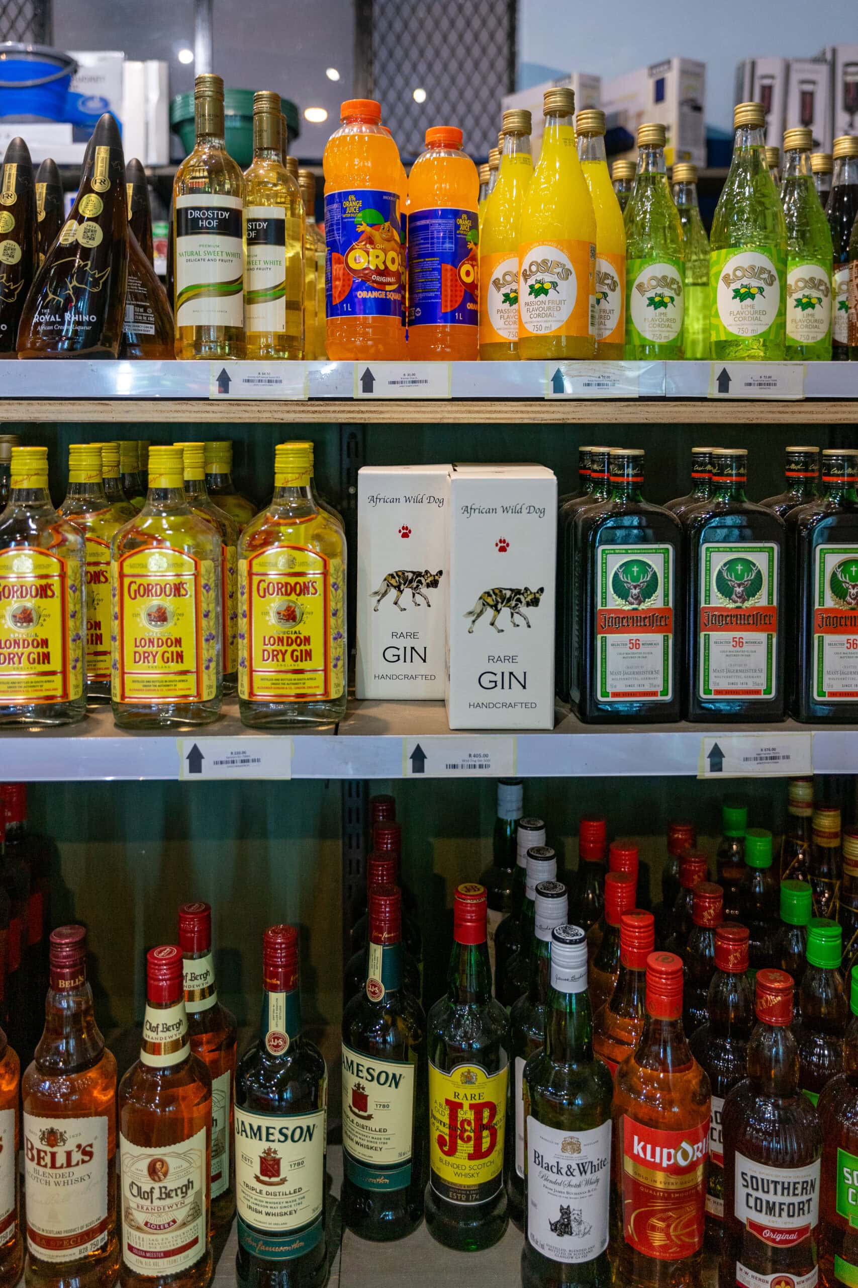 Selection of alcohol for sale at Shingwedzi Park Shop. There are gin, jameson whisky, klipdrift brandy, wine, and Oros cordial