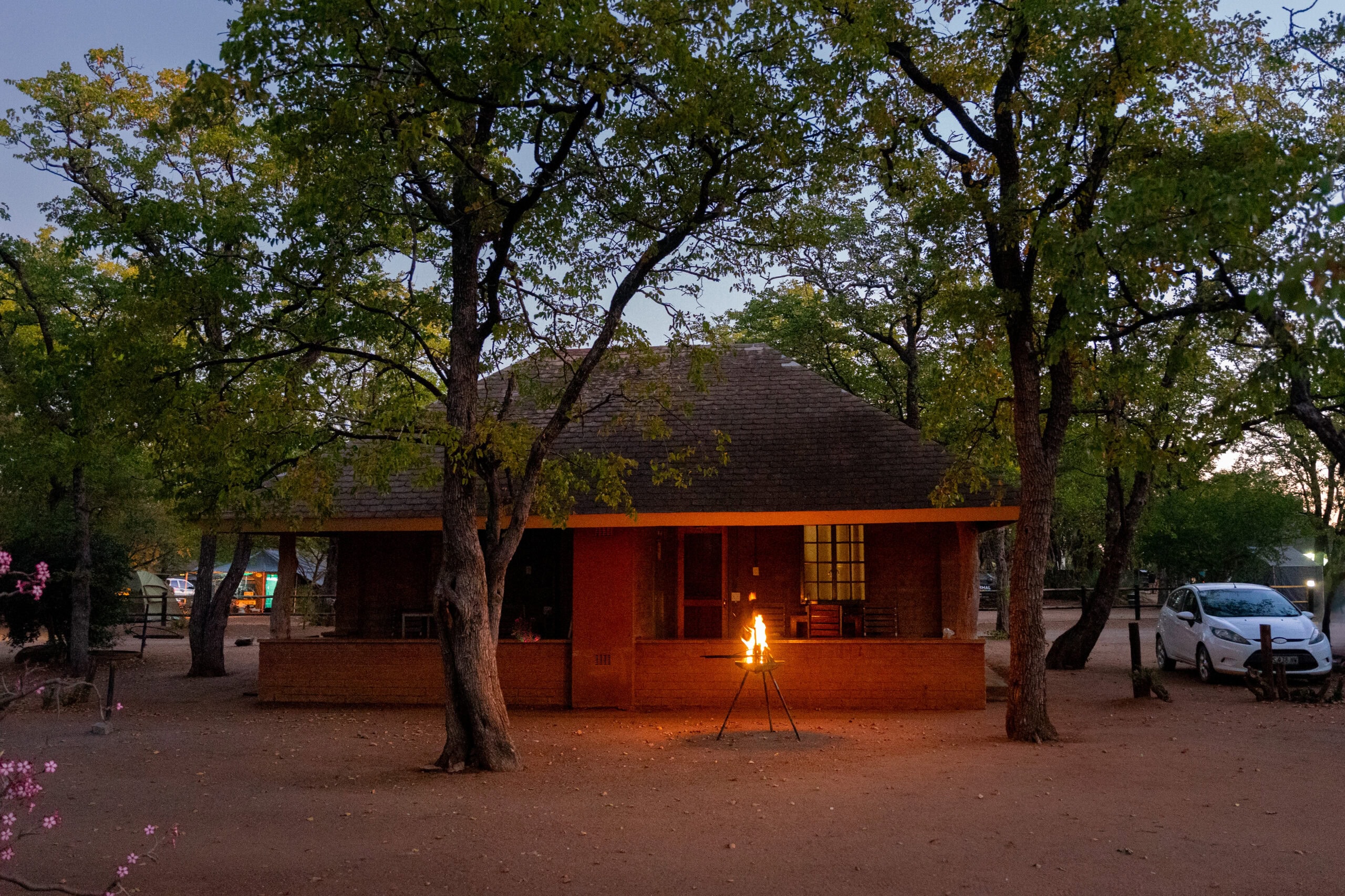 Hut EH3 where I stayed in Shingwedzi during my solo, budget trip to Kruger Park. My car is parked next to the hut, and there is a fire burning for bbq in front