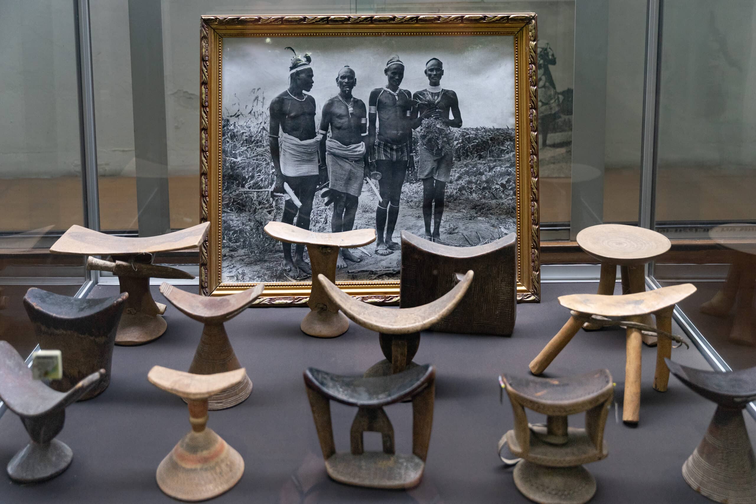 Headrests from the Omo region in Southern Ethiopia displayed alongside a black and white photo of 4 men from on Omo Valley tribe, National Museum of Ethiopia