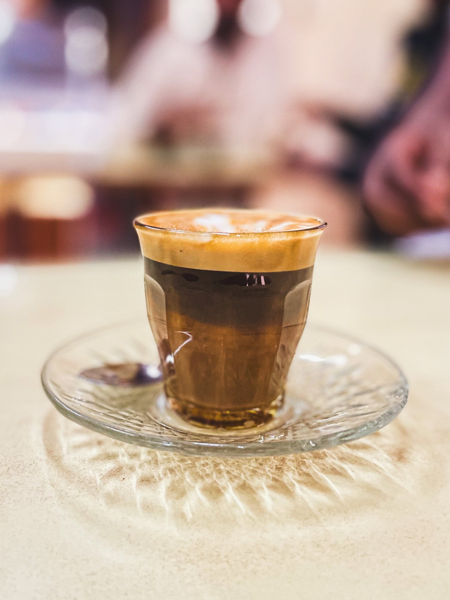 My macchiato, served in a glass cup and saucer I had at Tomoca coffee during my one day in Addis Ababa during a long layover