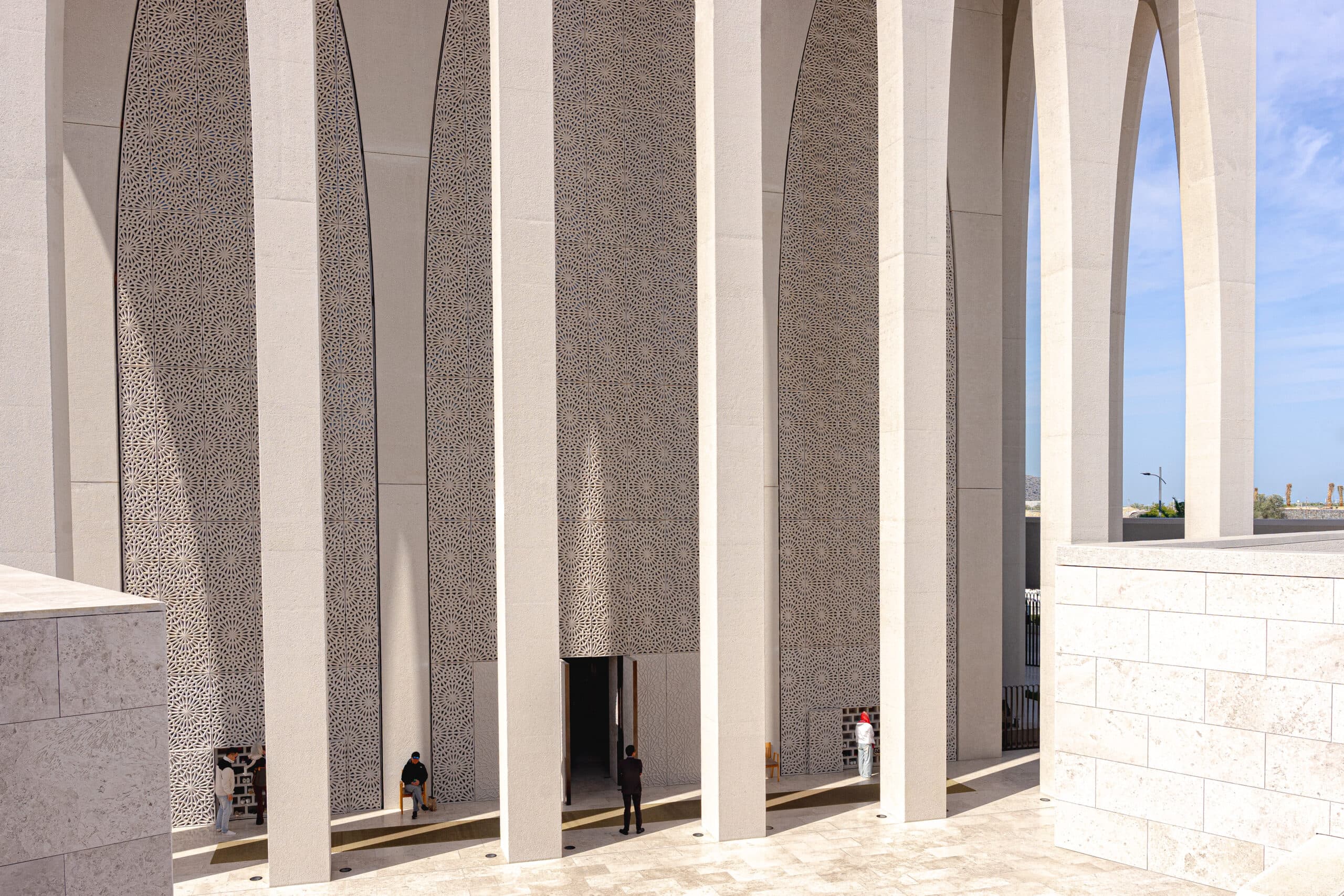 Lattice screens behind the seven arches of the The Imam Al Tayeb Mosque. You can see people entering the mosque