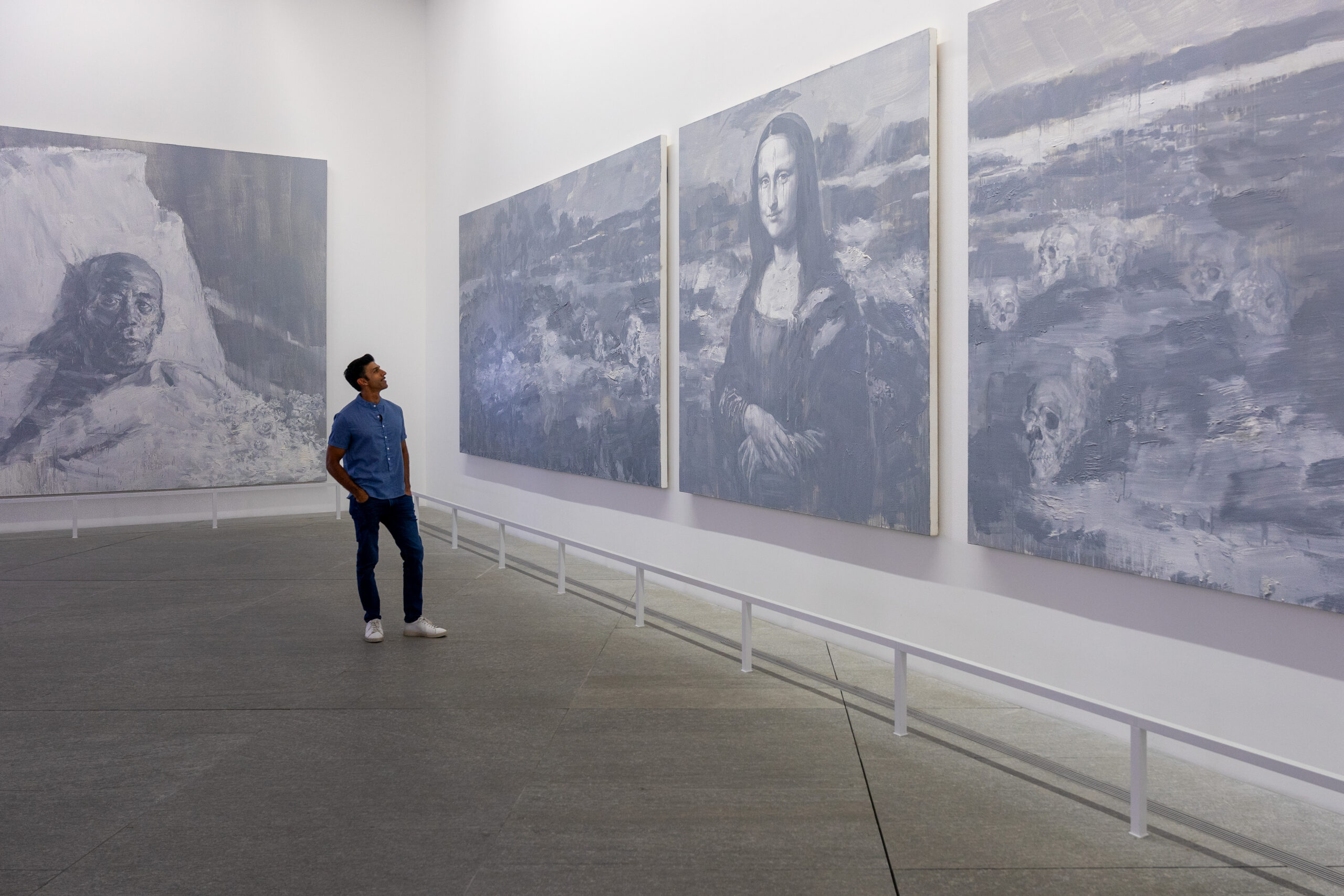 A man looks at The Funeral of Mona Lisa, a huge painting consisting ting of 6 panels at the Louvre Abu Dhabi