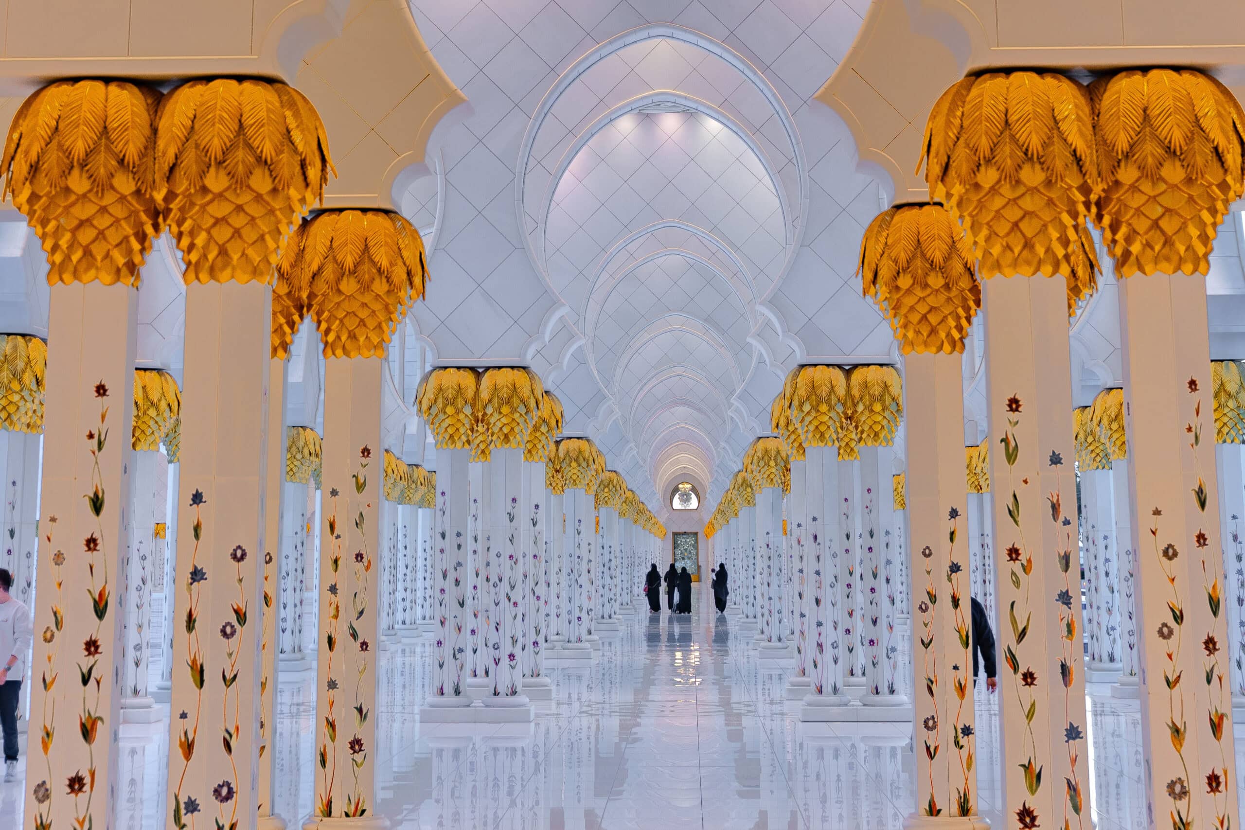 Thousands of white columns topped with golden capitals shaped like palm trees, inside the Sheikh Zayed Grand Mosque