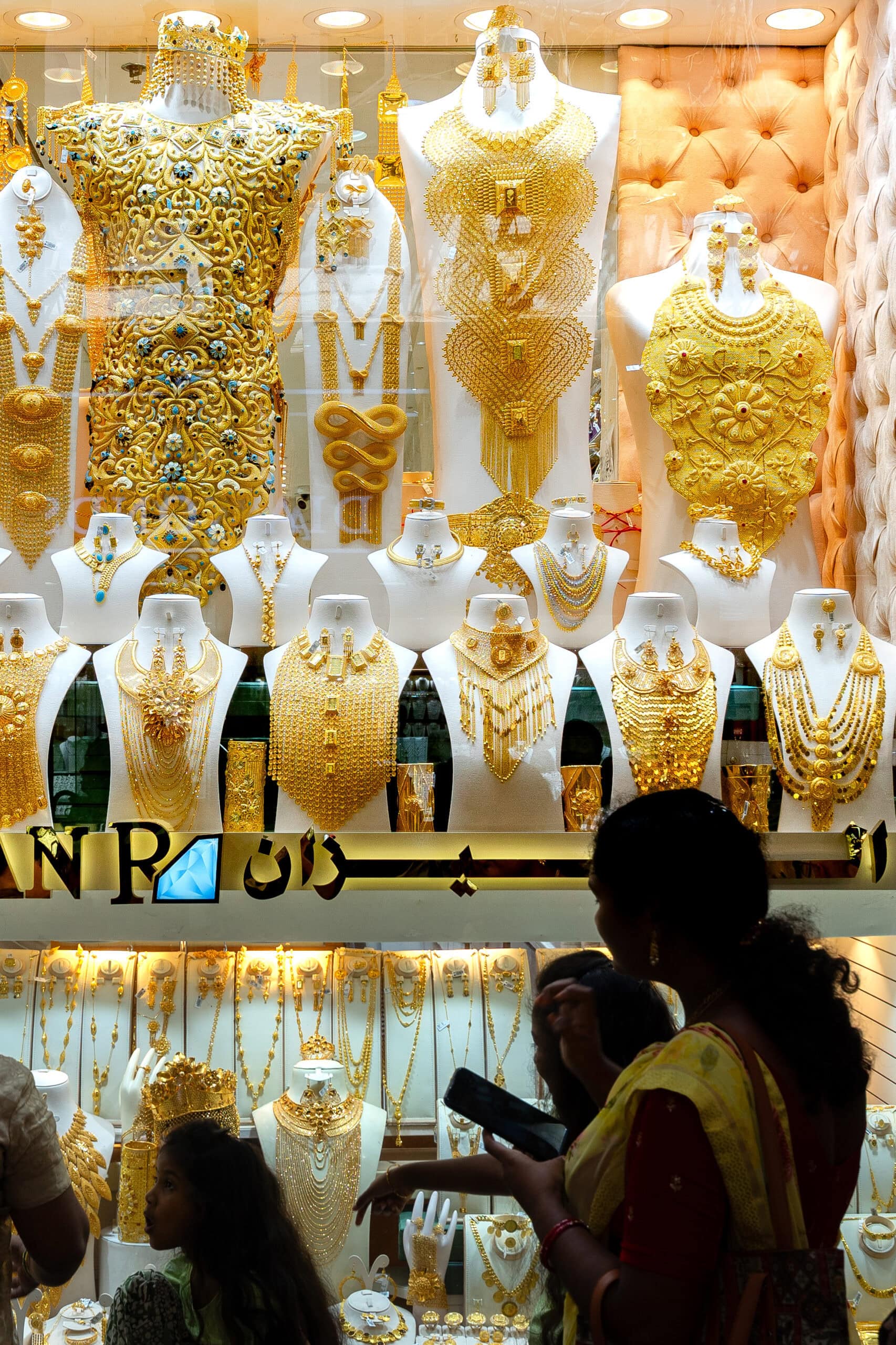 Shoppers pass by gold jewellery in Gold Souq Dubai