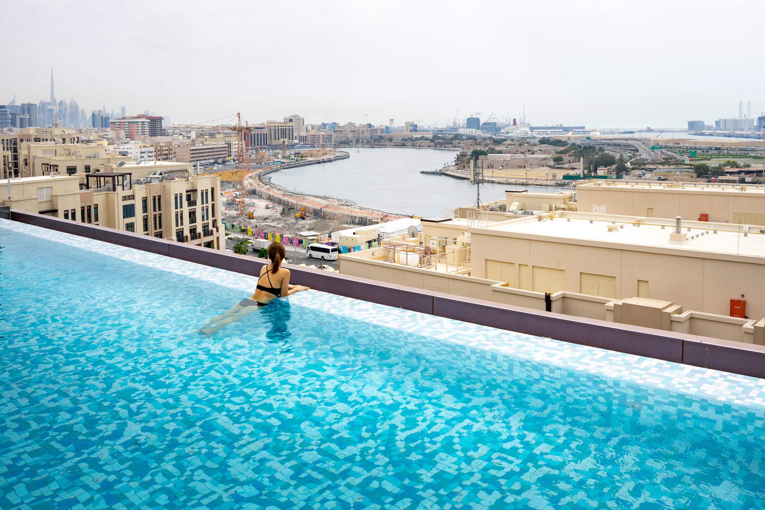 Jin looks out over Dubai Creek from the rooftop pool at Ibis Styles Deira in Dubai. This is a great budget hotel with a pool in Dubai for under $100