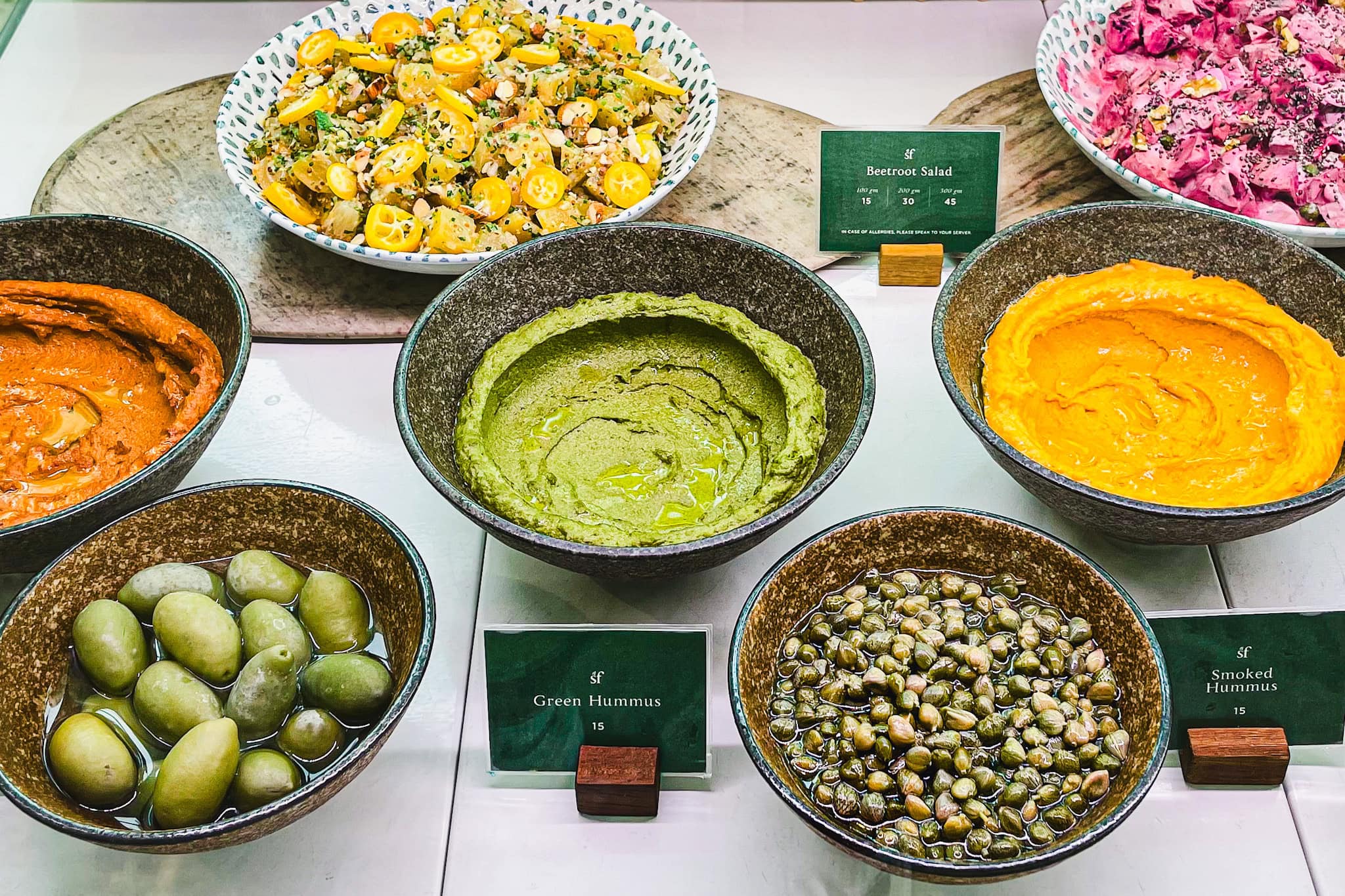 Middle eastern food. There are different kinds of hummus, salads and olives. Seen at a brunch cafe in Dubai
