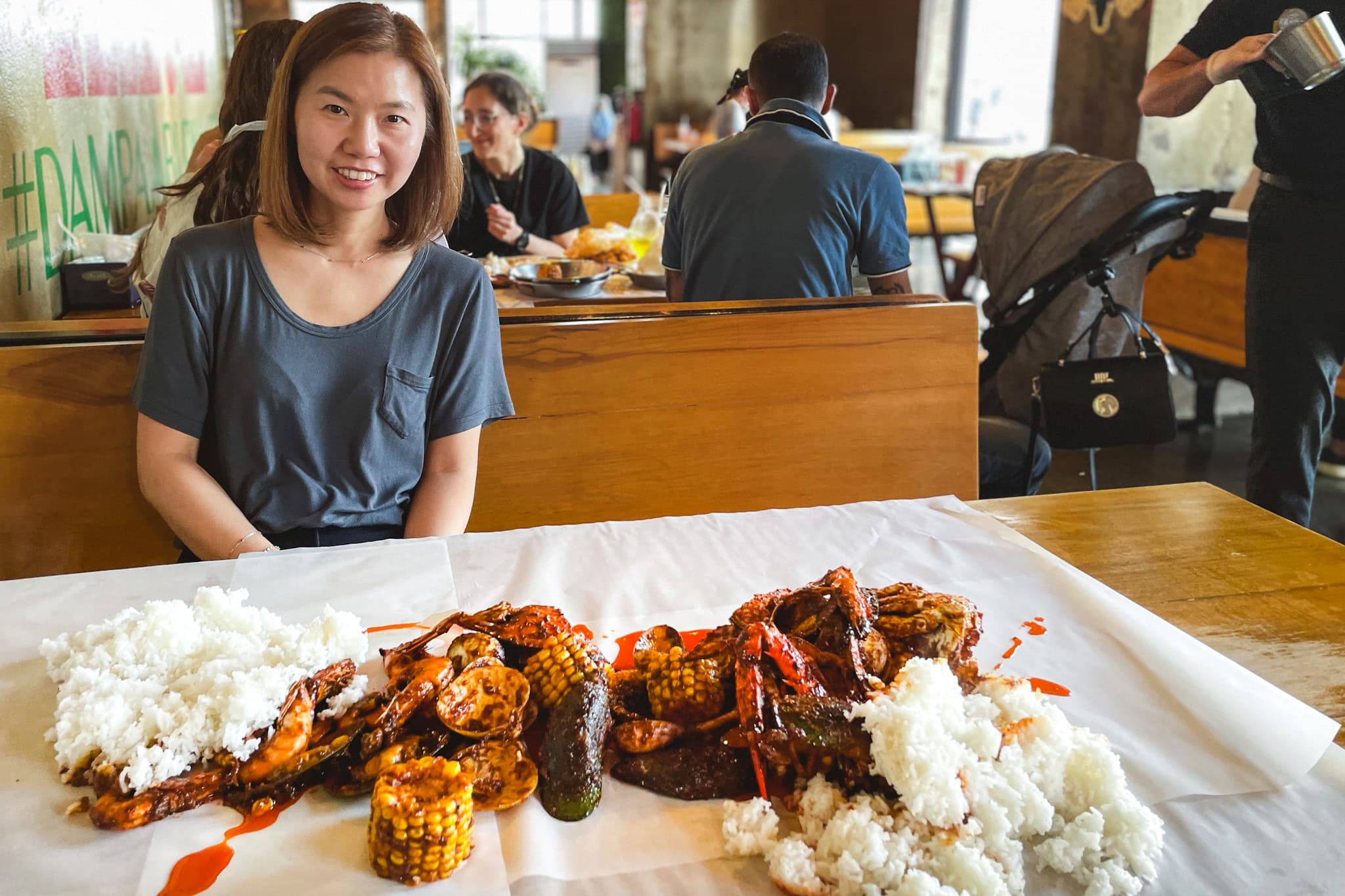 Jin looks excited. On the table is a mountain of rice and seafood in Cajun sauce. This was lunch at Dampa Seafood Grill in Abu Dhabi