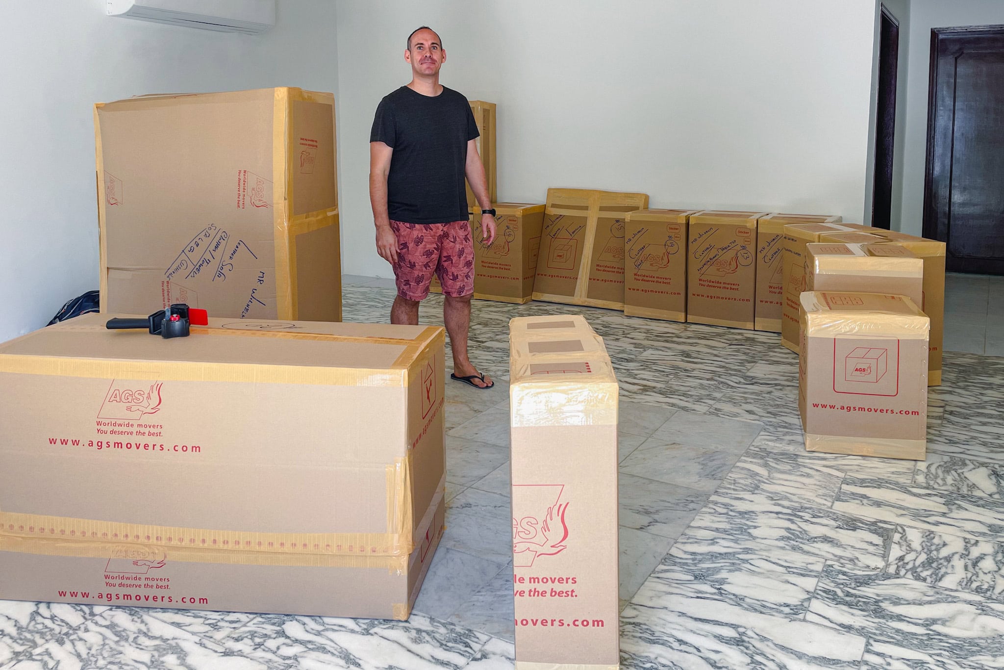 I. amtaping up boxes for our move away from the UAE. There are 13 boxes standing in our empty living room in Al Ain