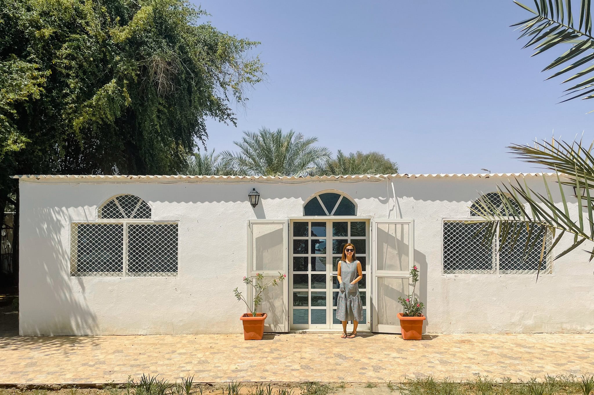 Jin standing in front of our house in Al Ain. It's a low, flat roofed house.