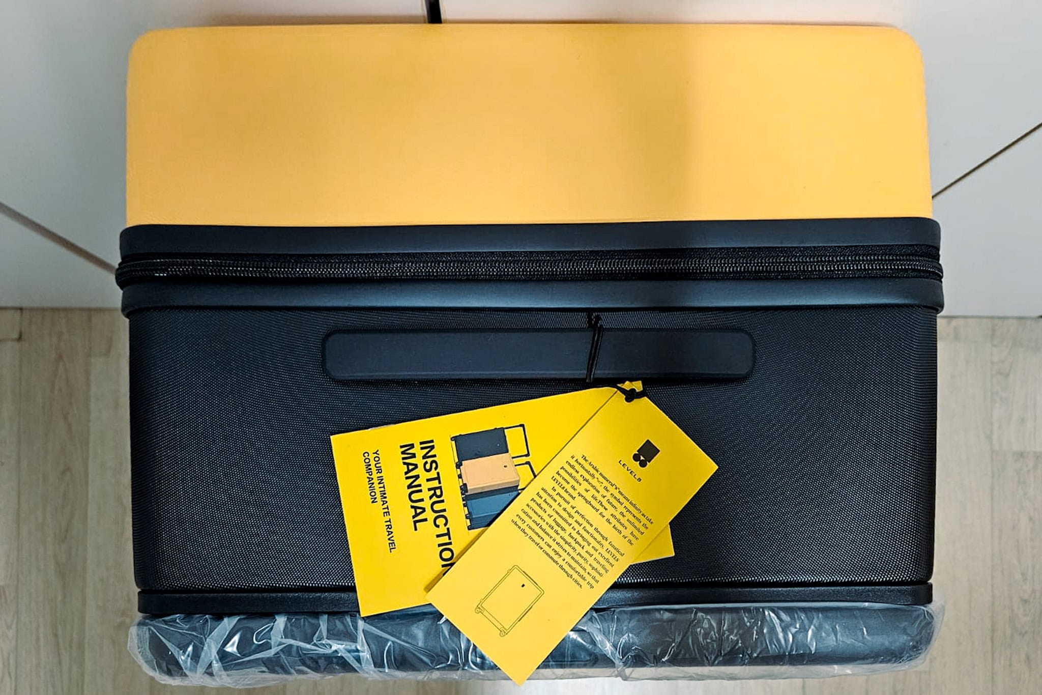 The limited edition yellow black 26 inch Voyageur from Level* seen from the top. You can see the instruction manual tag attached to the top handle