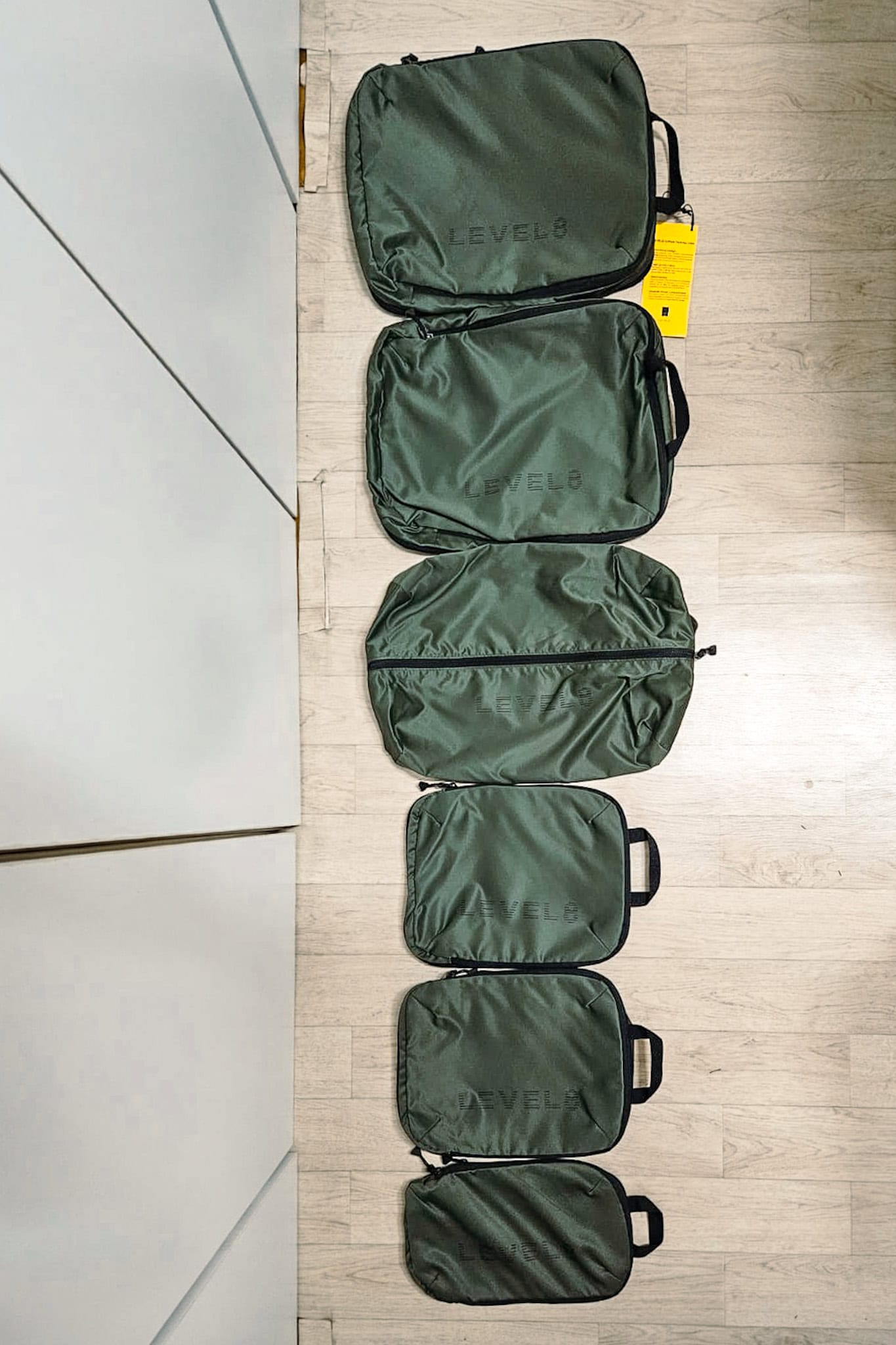 Six packing cubes from Level8 laid out on the floor for size comparison. I received this set with the Voyageur 26 inch in return for an honest product review