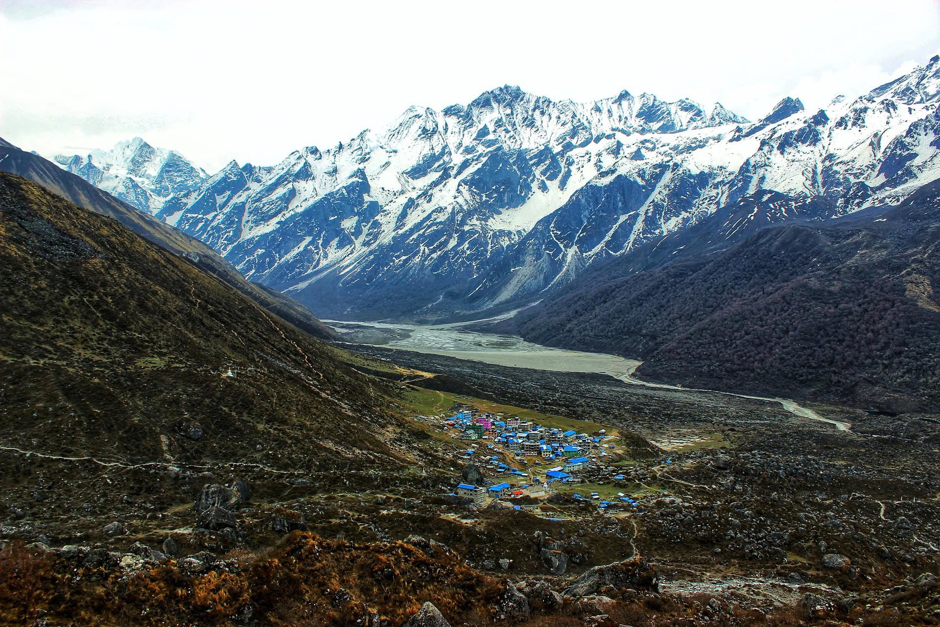 Remote mountain village in the Langtang Valley with snow-capped peaks and lush valleys.