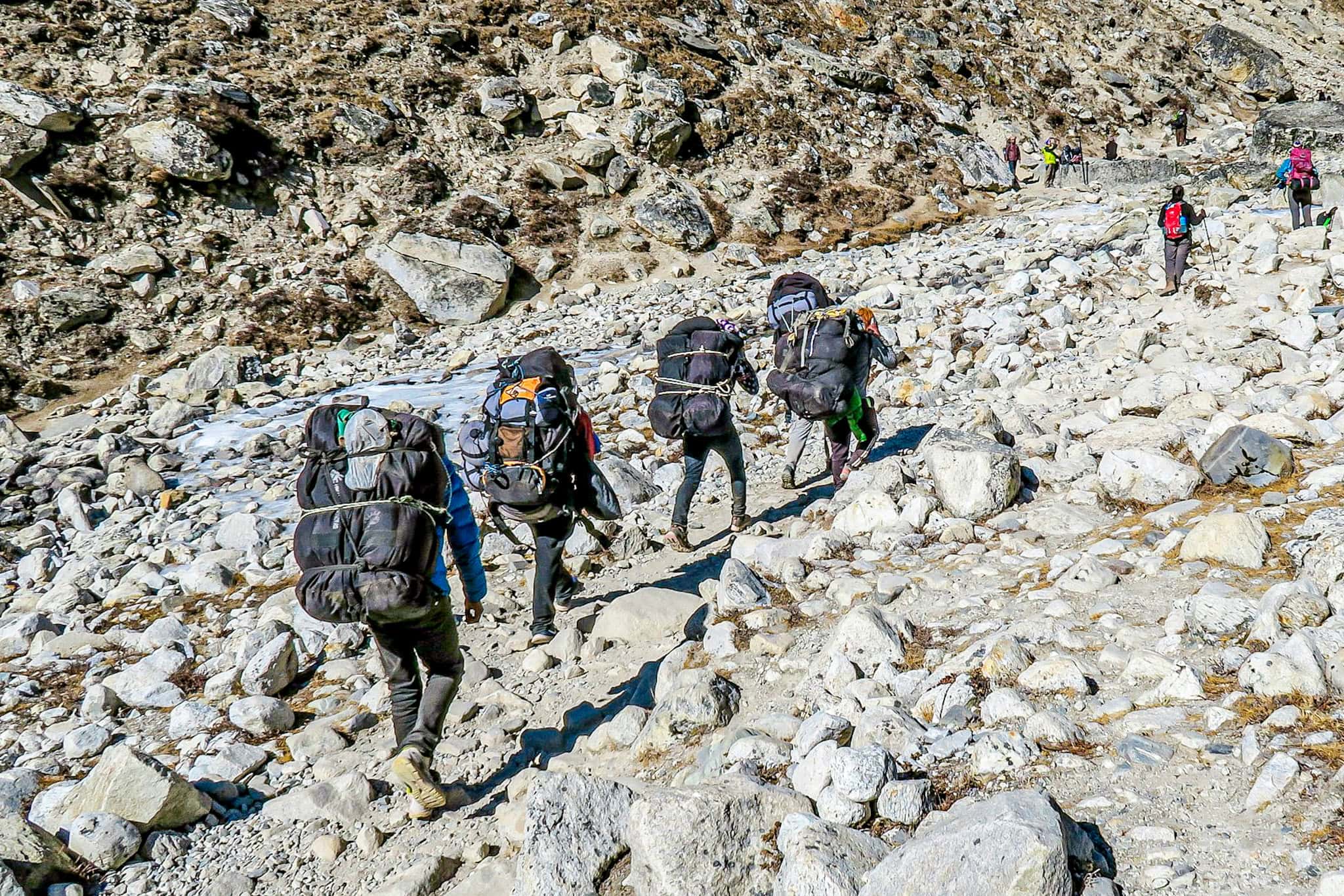 Hikers trekking through rocky mountain terrain as part of an outdoor adventure experience.