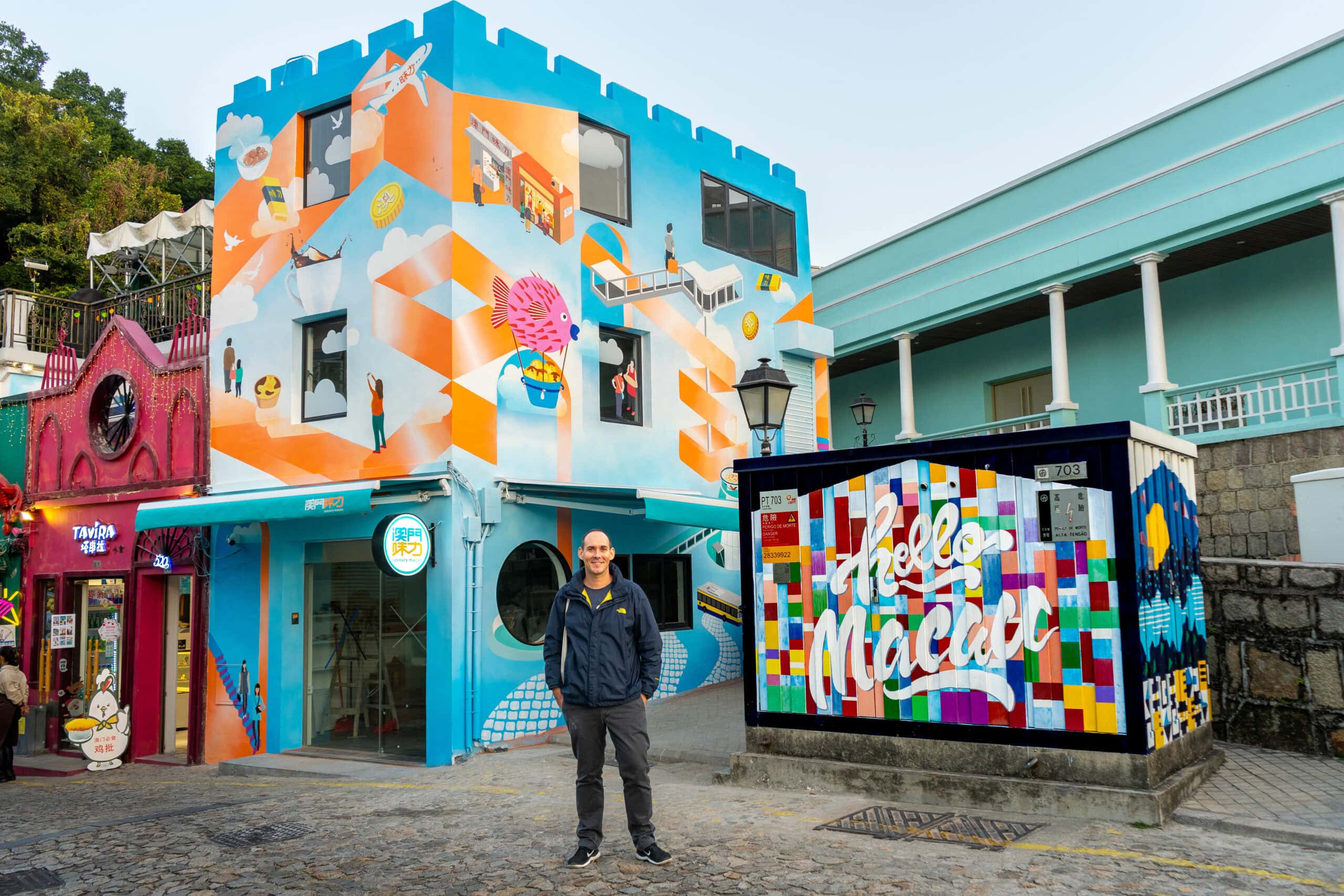 I am standing in front of a colourful building covered in street art, Calcada do Quartel, Macau