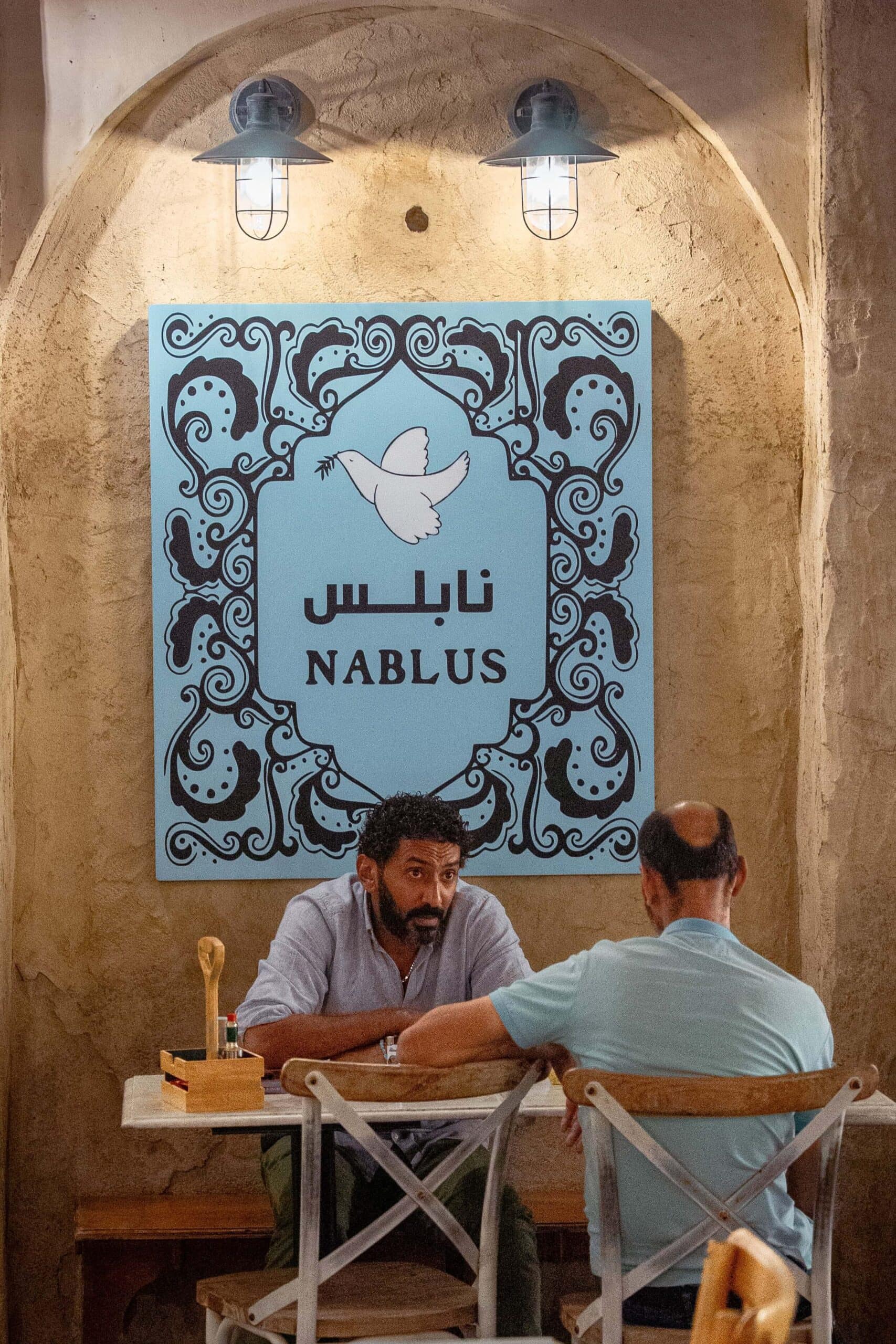 Two Middle Eastern men sit chatting at Nablus Cafe in Al Seef, Old Dubai