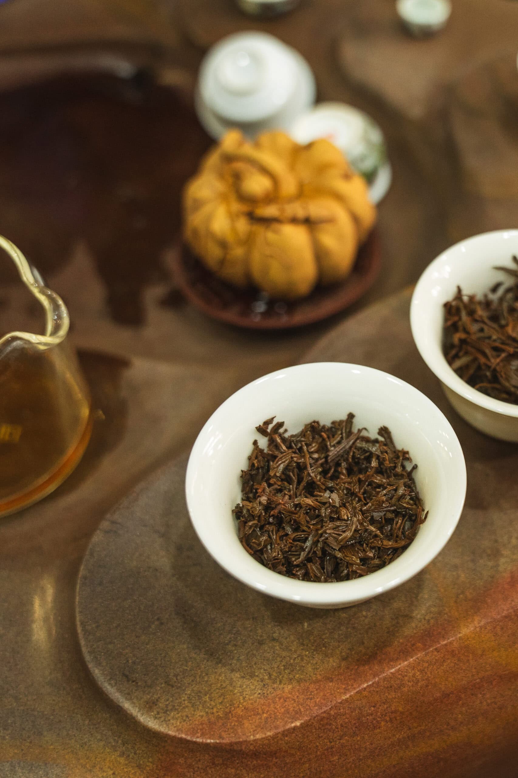 Two cups full of loose leaf tea  sitting on a tea tray