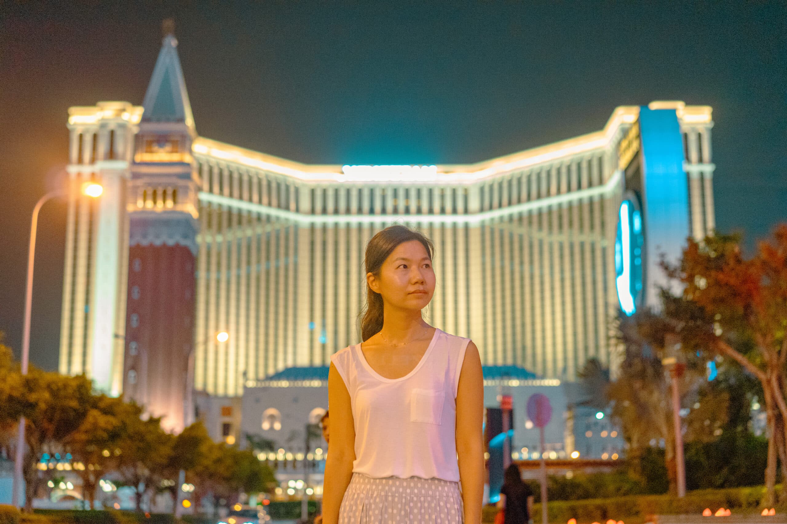 Jin stand in front of the Venetian casino in Macau, after dark