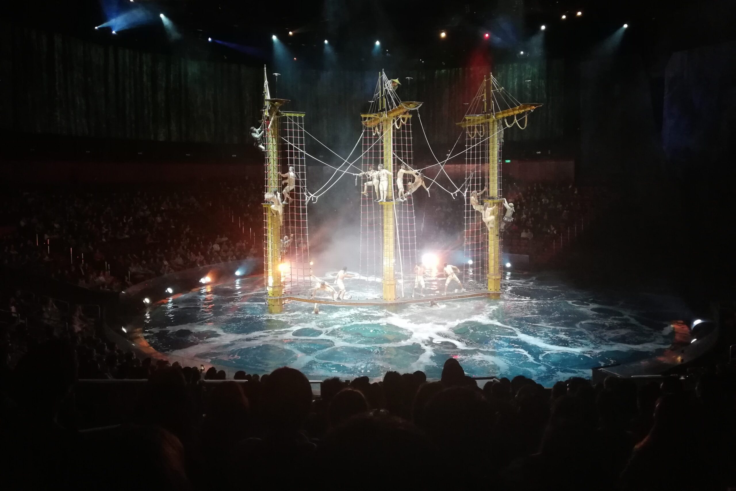 Acrobats swinging and diving from a ship into the water, House of Dancing Water