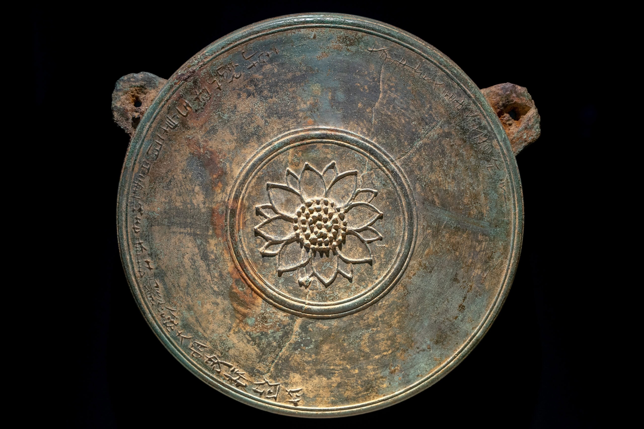 A bronze disk with a lotus symbol