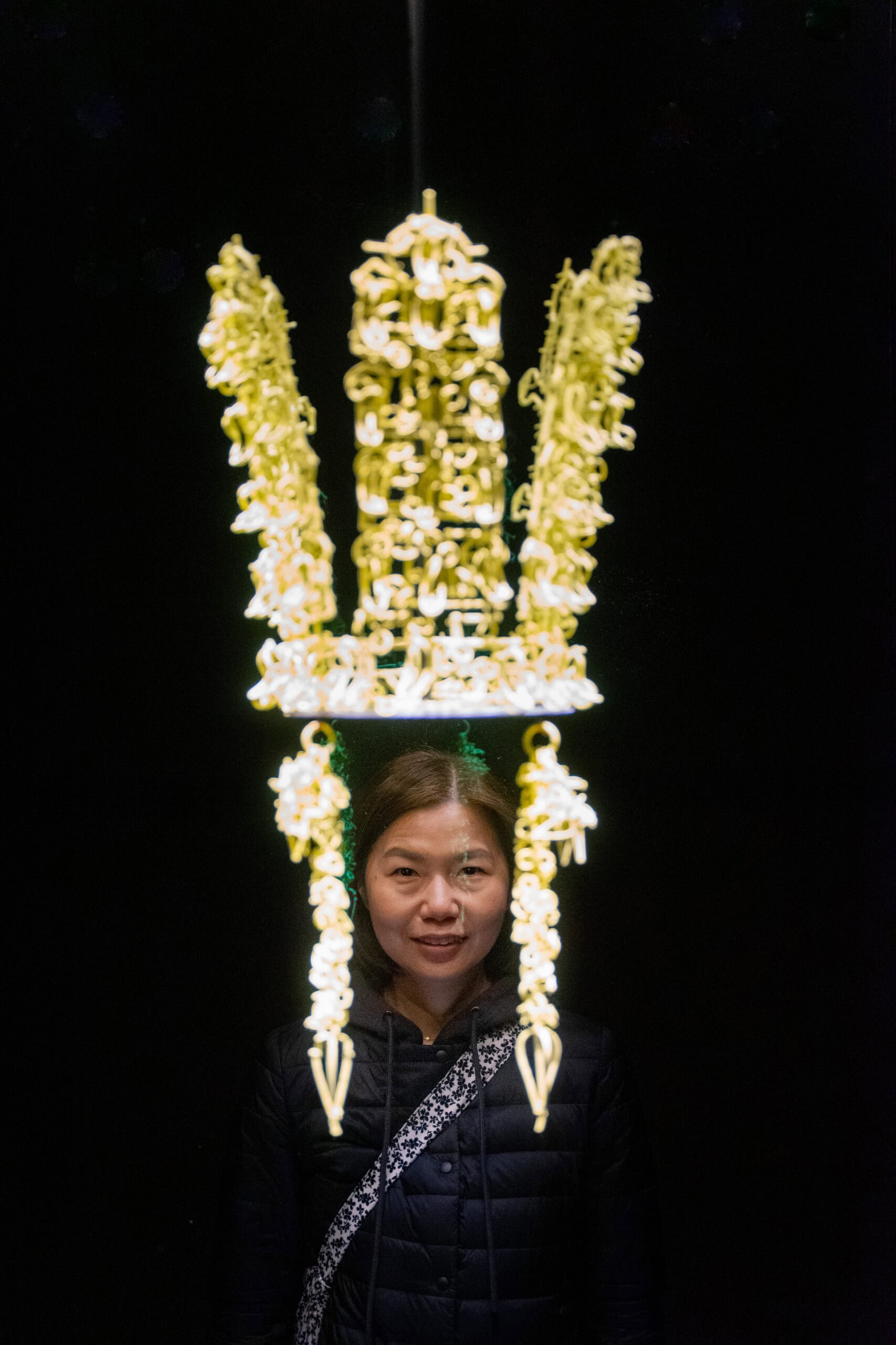 Jin poses behind a Silla crown display making it look like she's wearing the crown