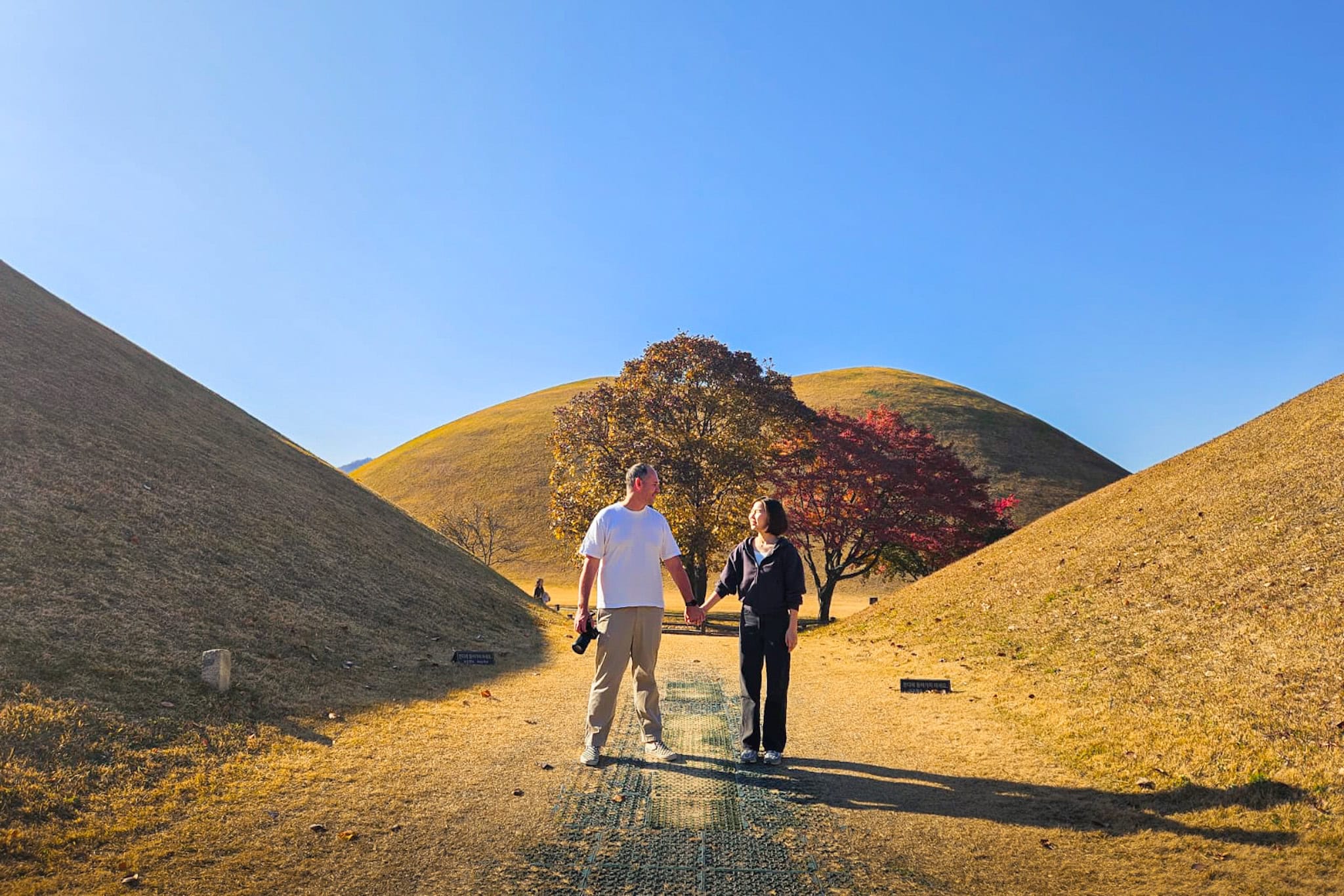Jin and I are standing at a famous photo spot in the Daereungwon Tomb Complex in Gyeongju