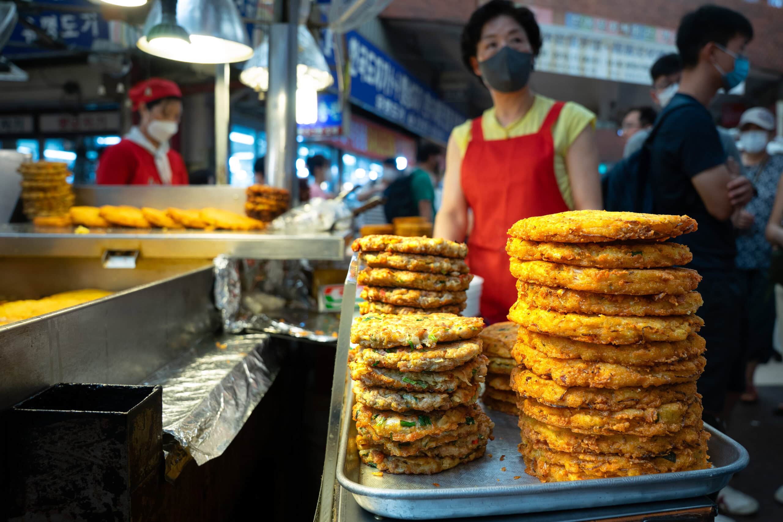 stacks of crispy, golden fried Bindaetteok at Gwangjang market in Seoul