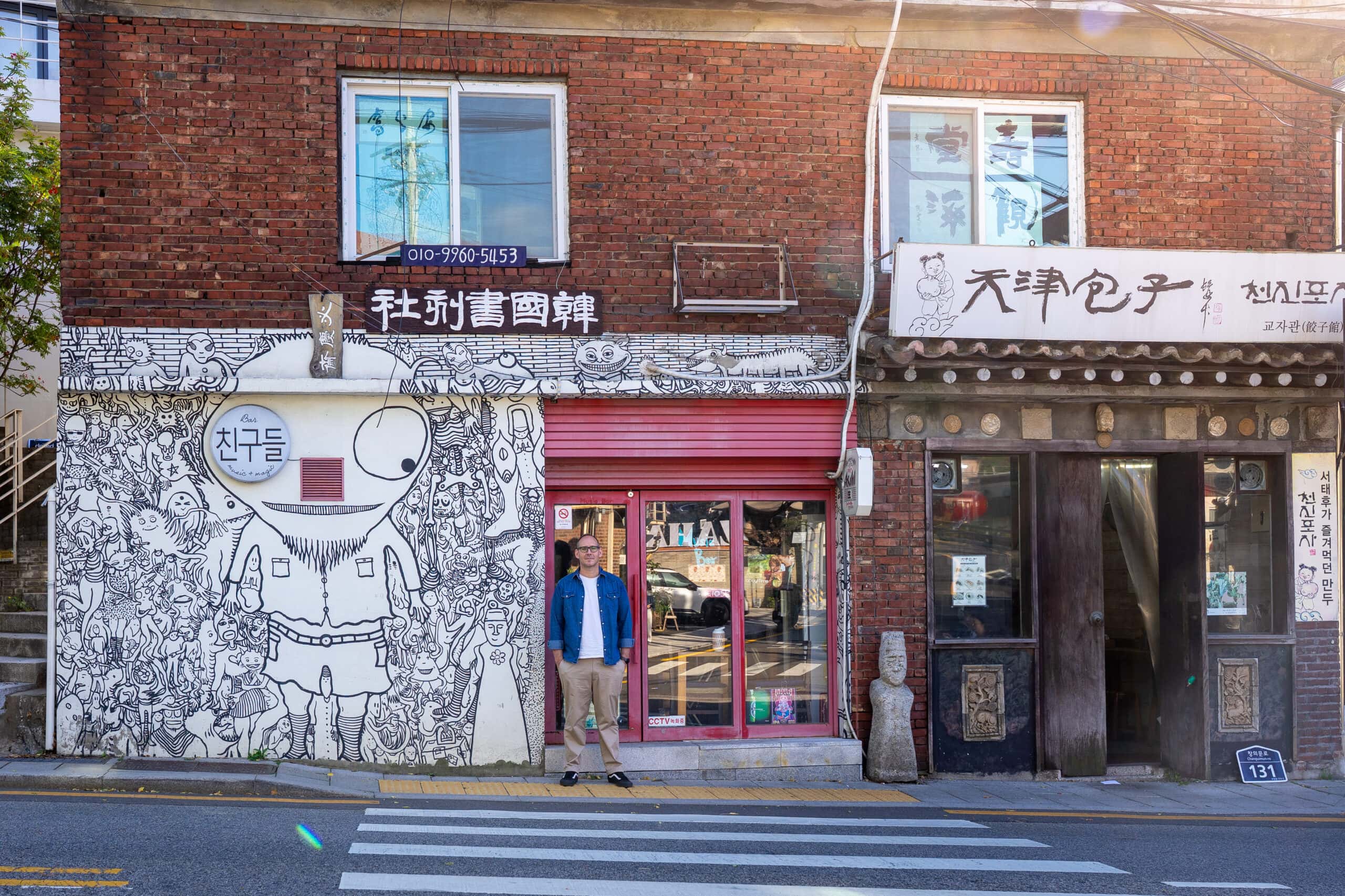 I am standing in front of a quirky mural in Buam-dong, one of my favourite neighbourhoods in Seoul