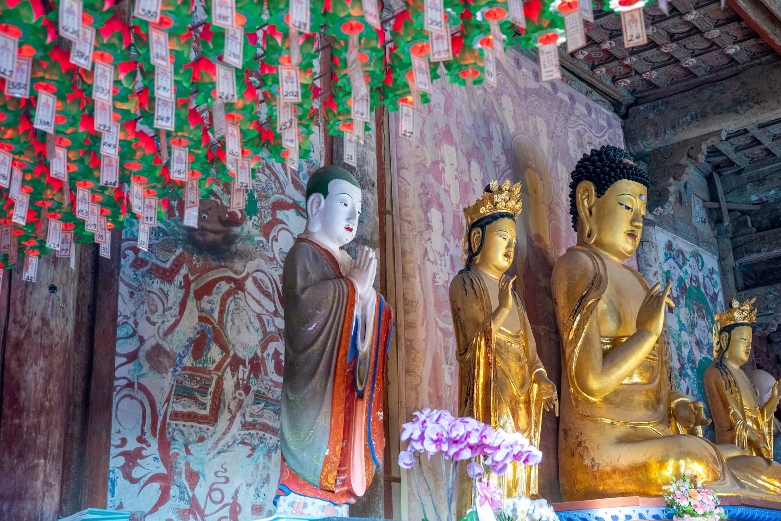 Golden Buddha figures and deities inside the main prayer hall at Bulguksa Temple