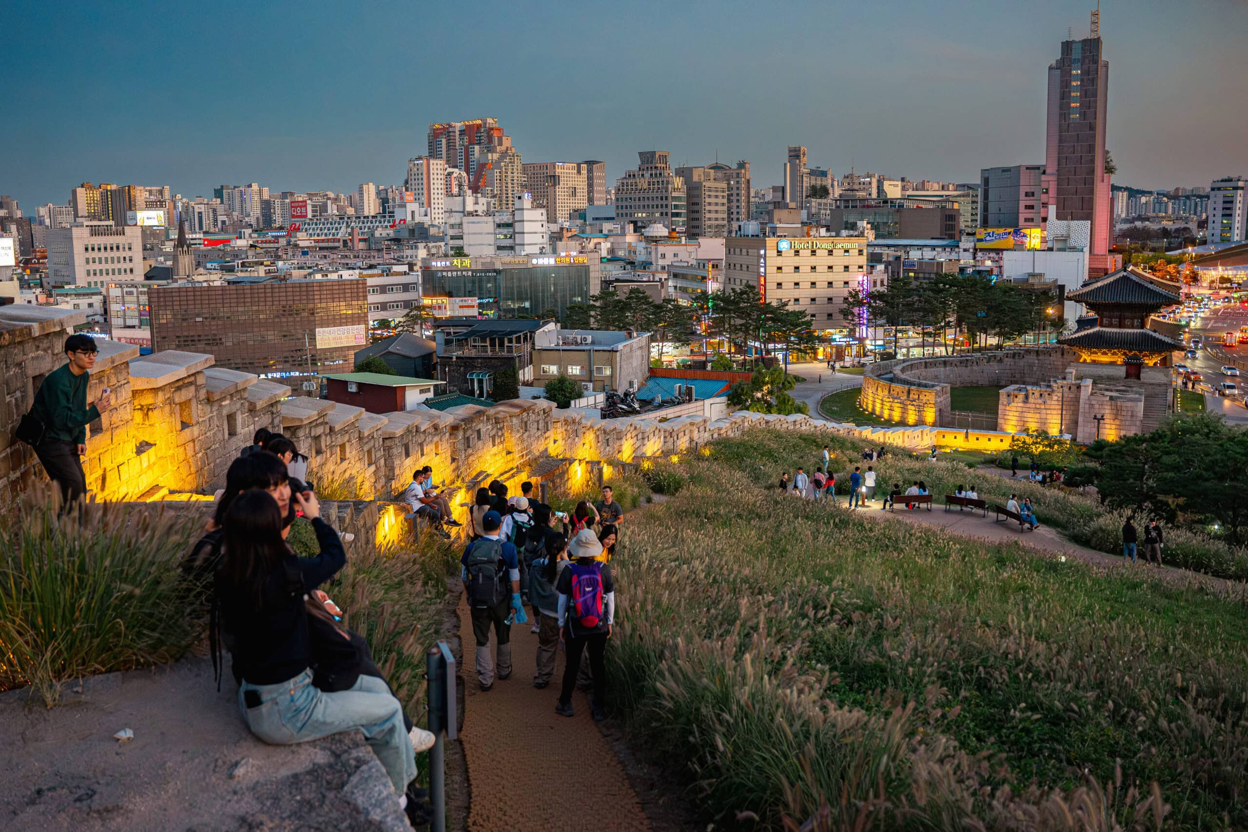 People watching sunset from the old city wall on a hill in Dongdaemun