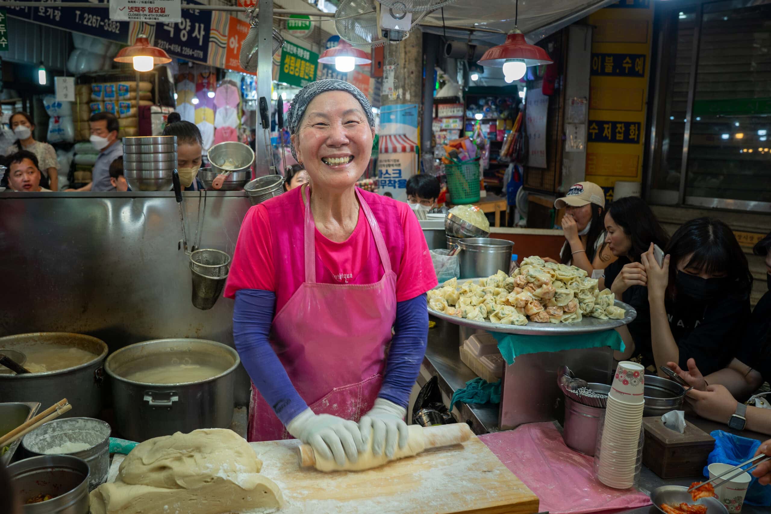 Cho Yonsoon, the Netflix Lady of Gwangjang Market rolling out her noodles while she smiles as I take a photo