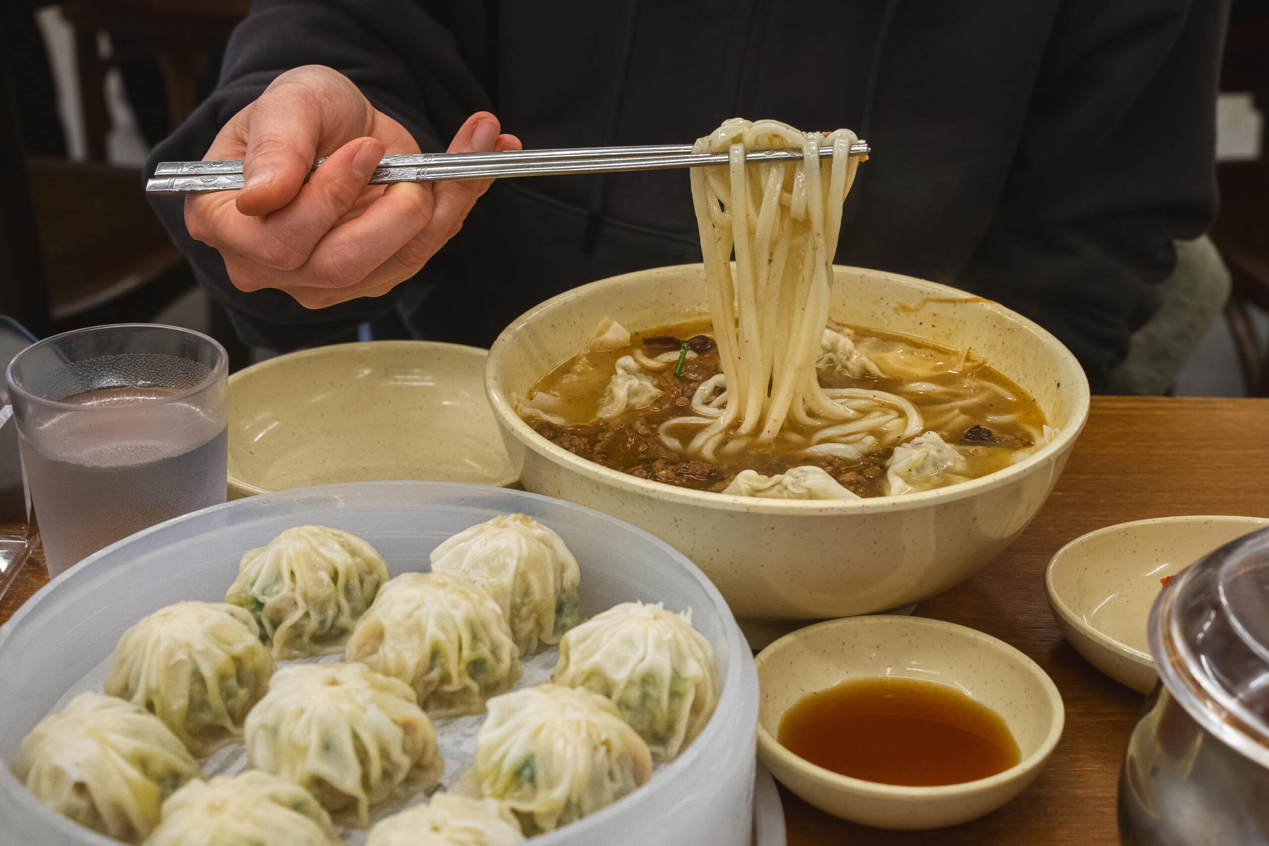 A bowl of noodles and a portion of steamed dumplings at Kyoja in Myeondong