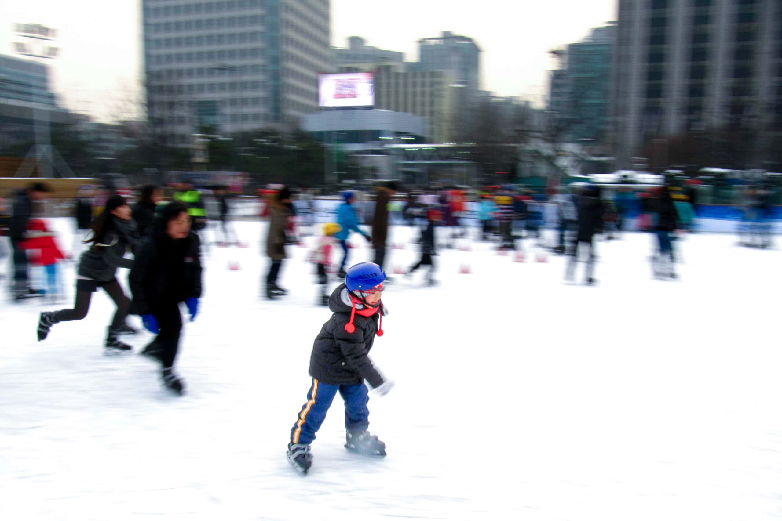 a young boy skates on the ice rink in Seoul Plaza