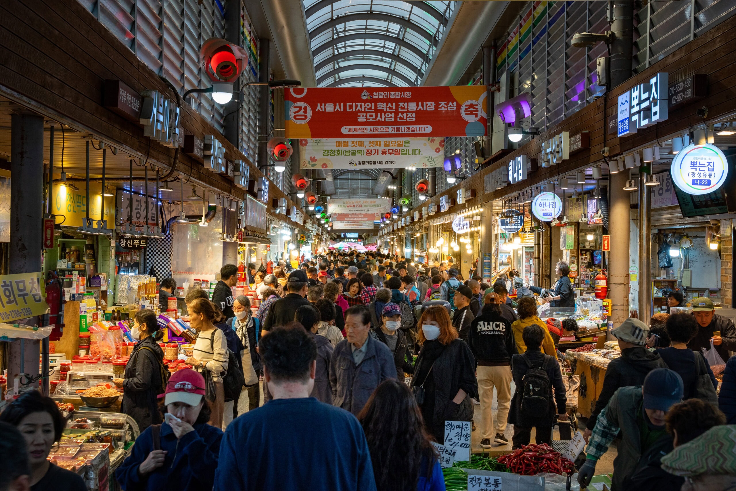 crowds of people walking through a covered traditional market in Seoul