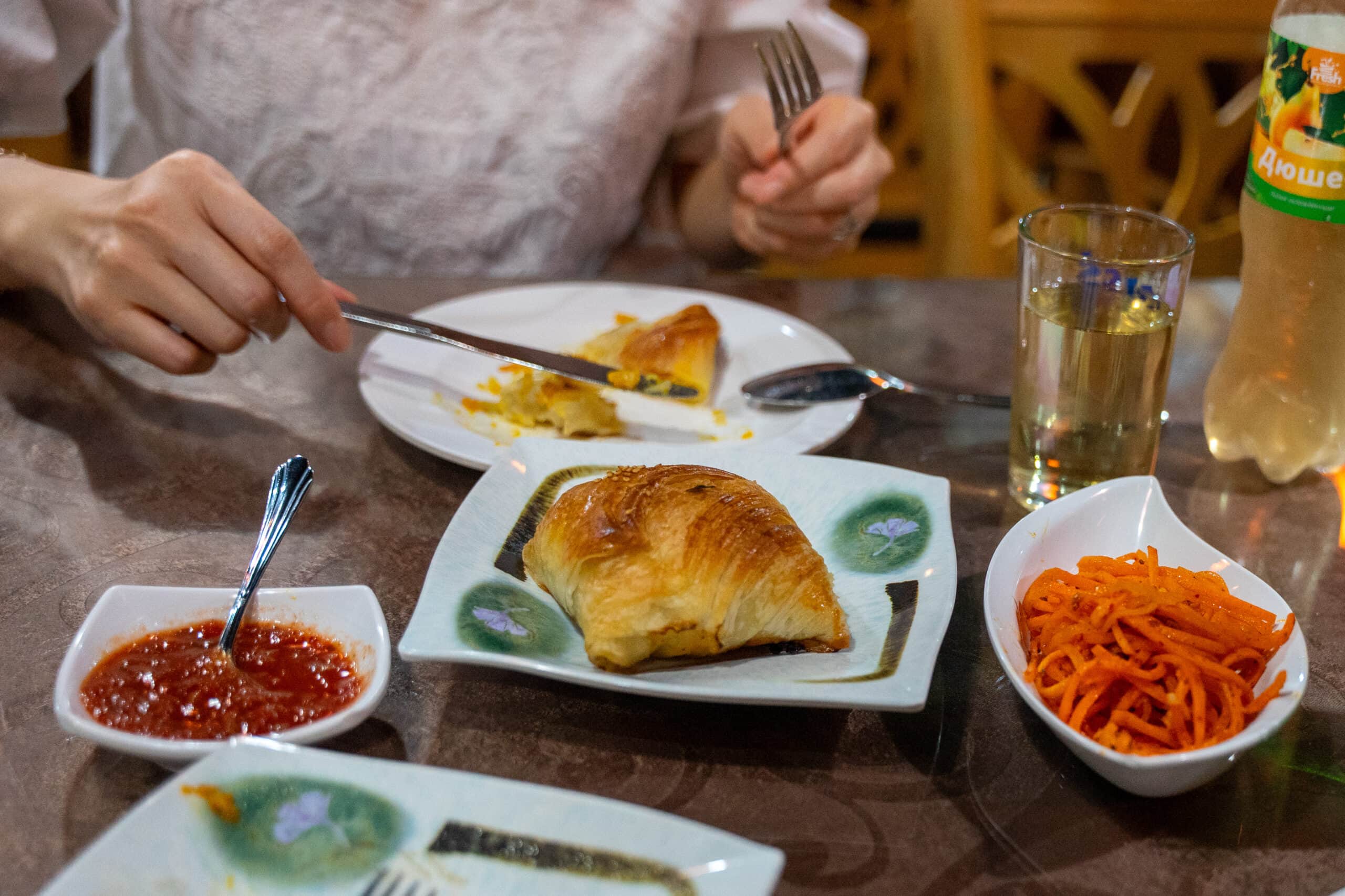 A baked samsa with a side of pickled carrots and spicy sauce from Fortune Uzbek restaurant in Seoul