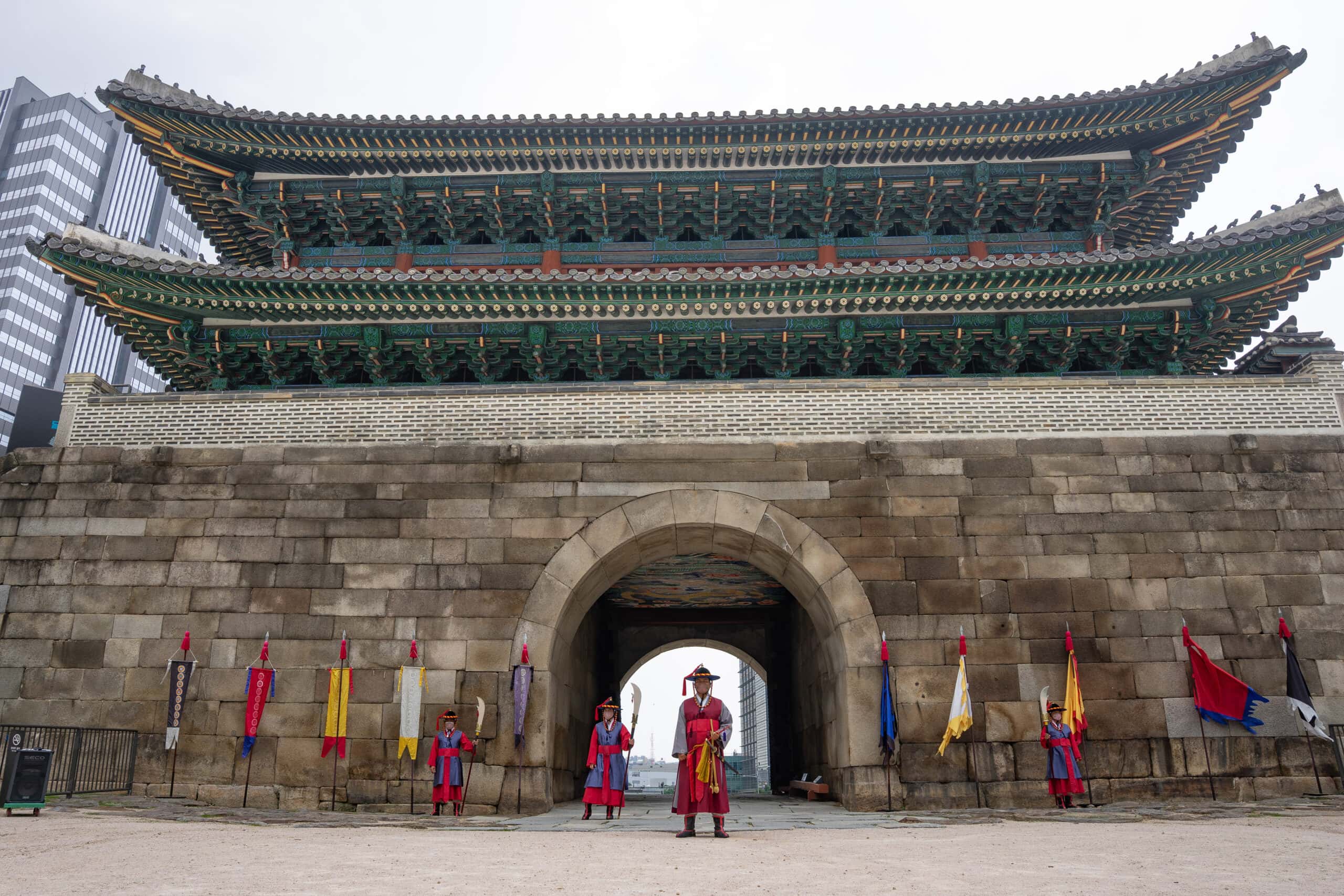 Guards dressed in traditional clothes stand in front of the Namdaemun gate