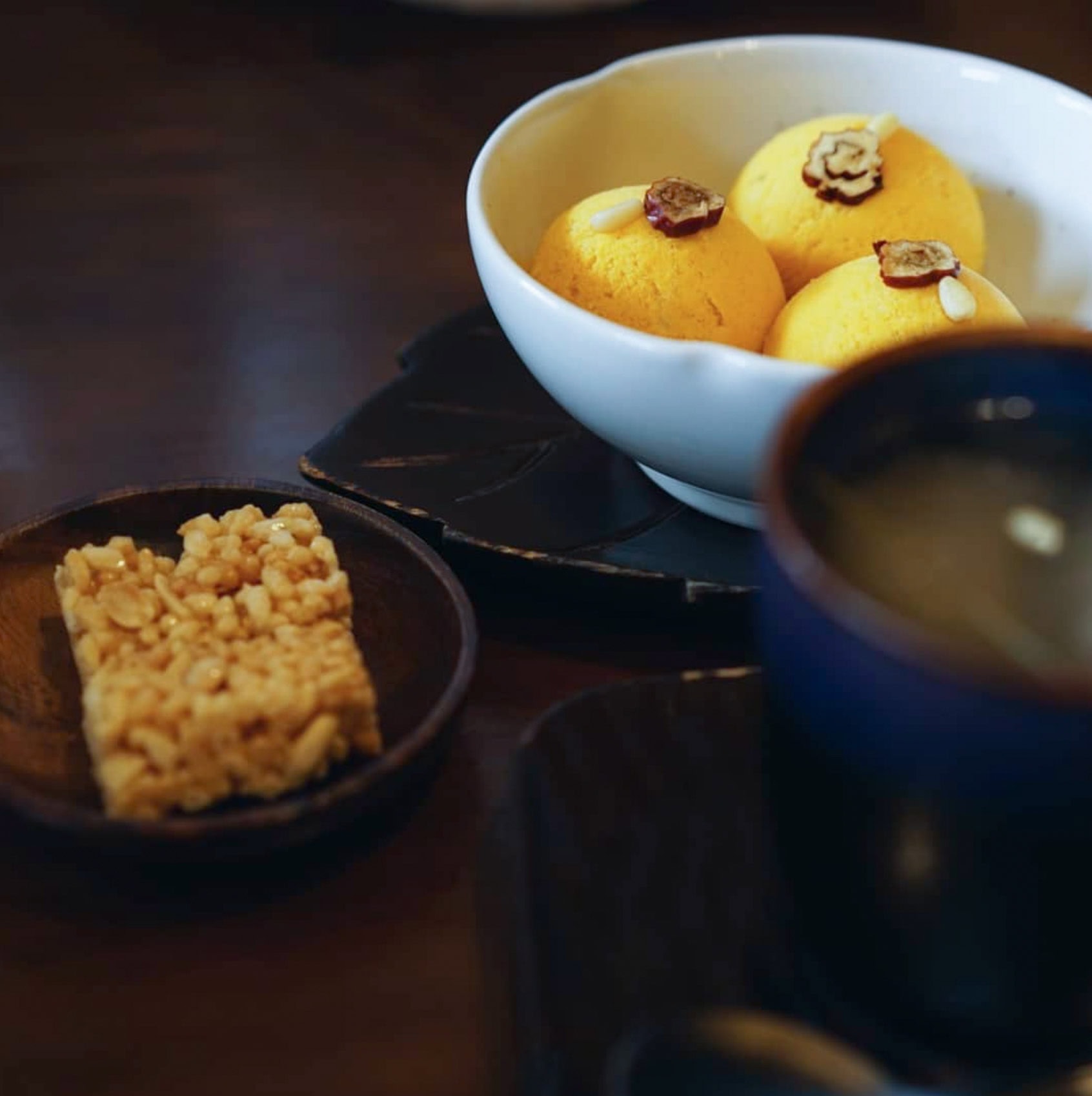 three balls of pumpkin ice cream served in a white porcelain bowl