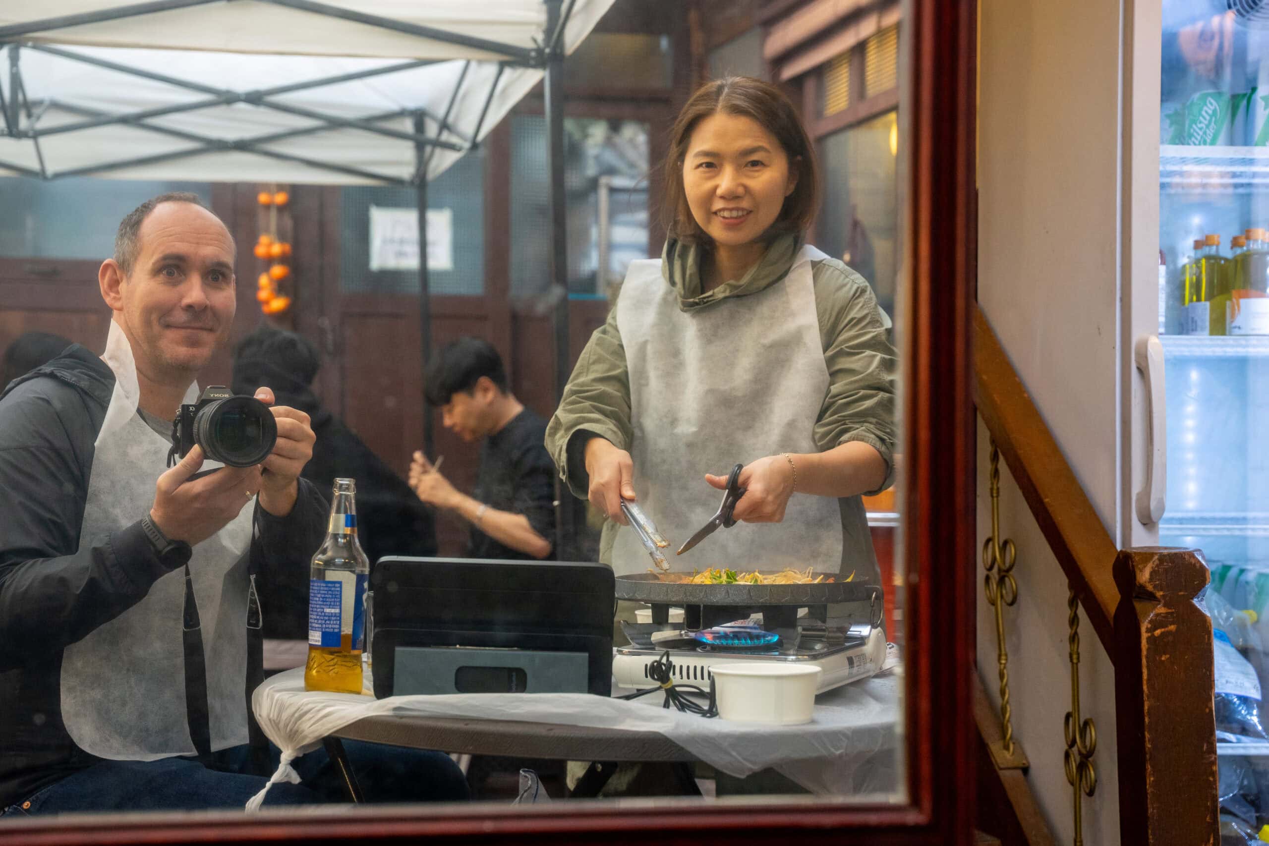 Jin cuts the meat with a pair of scissors while I take a photo in the mirror