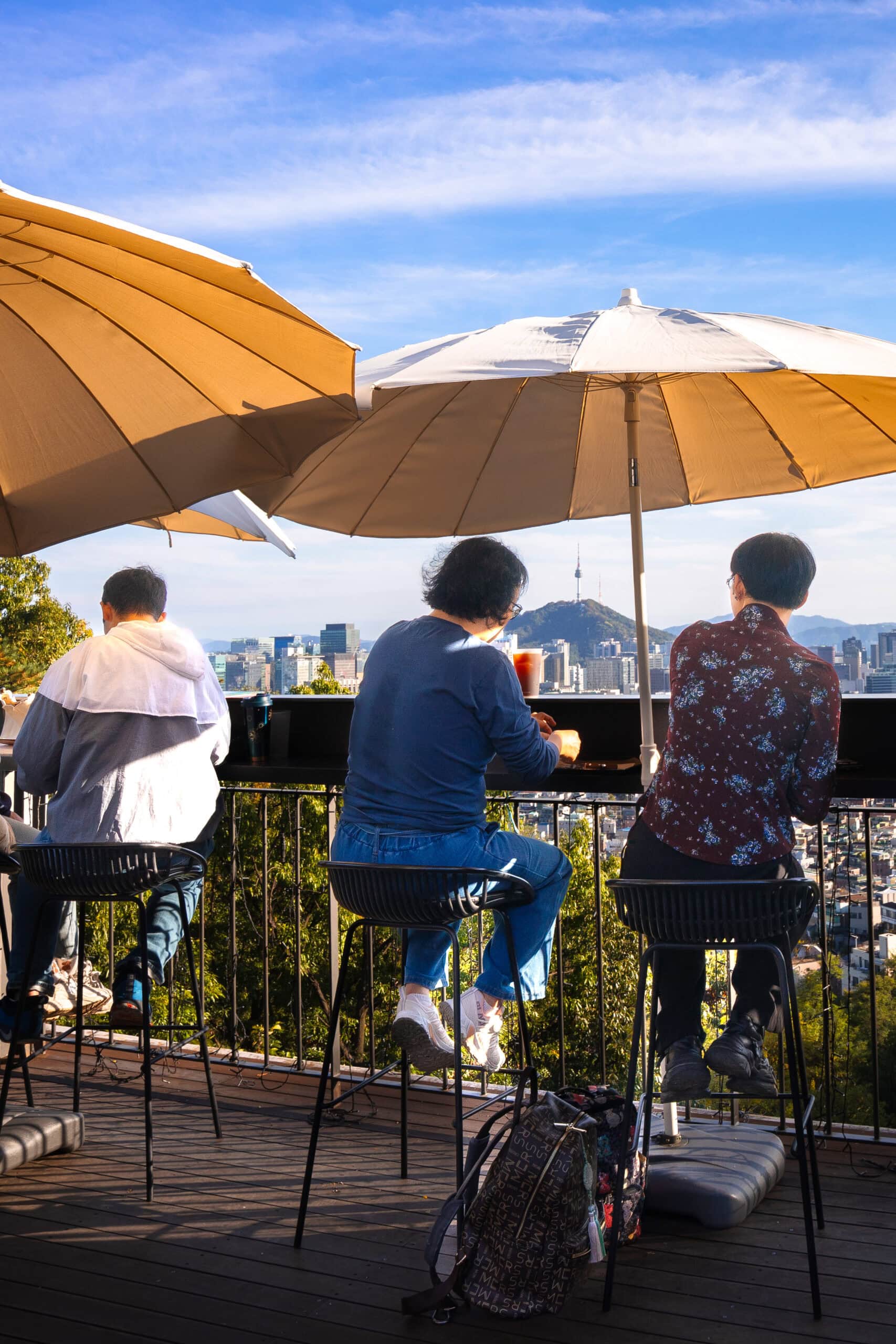 People sit under white canvas umbrellas at The Forest Chosochaekbang and admiring the view of Seoul 