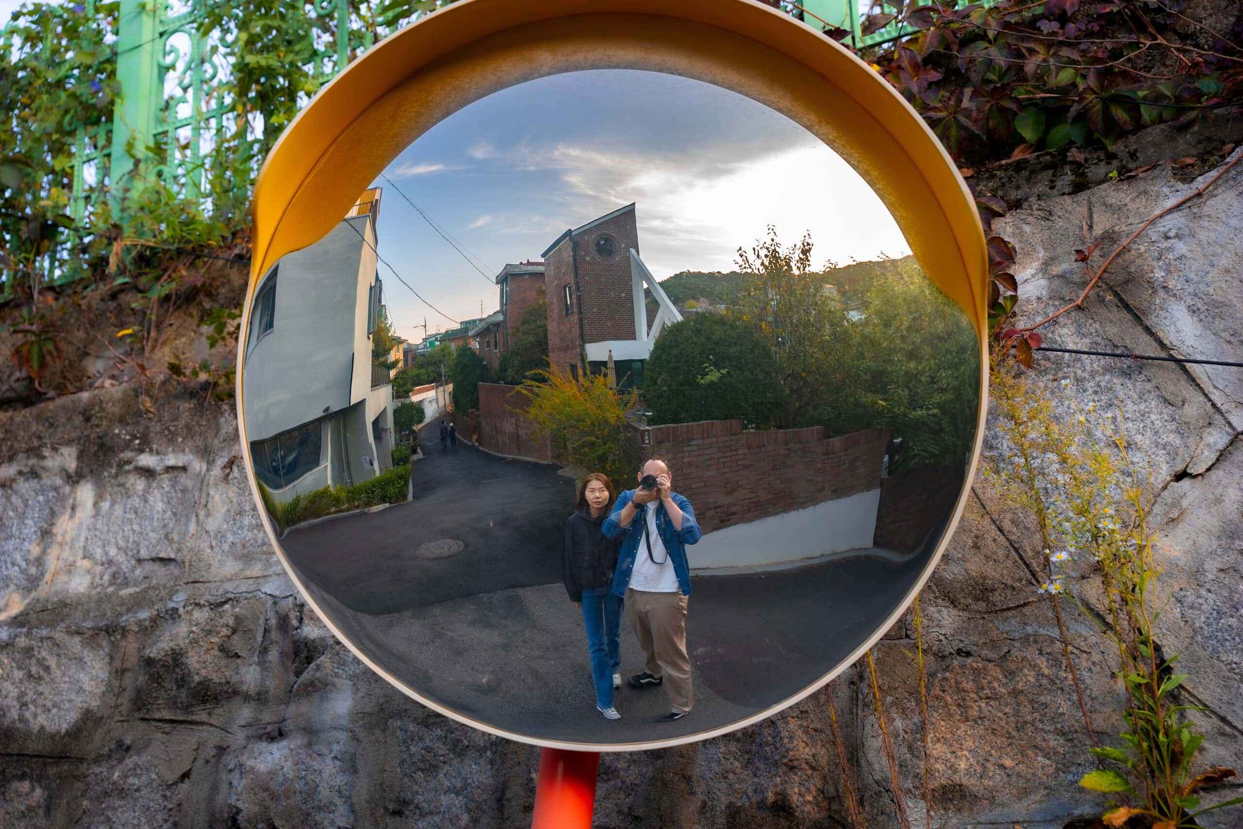 I am taking a photo of us reflected in a fish eye mirror on the street of Buam-dong during our afternoon walk