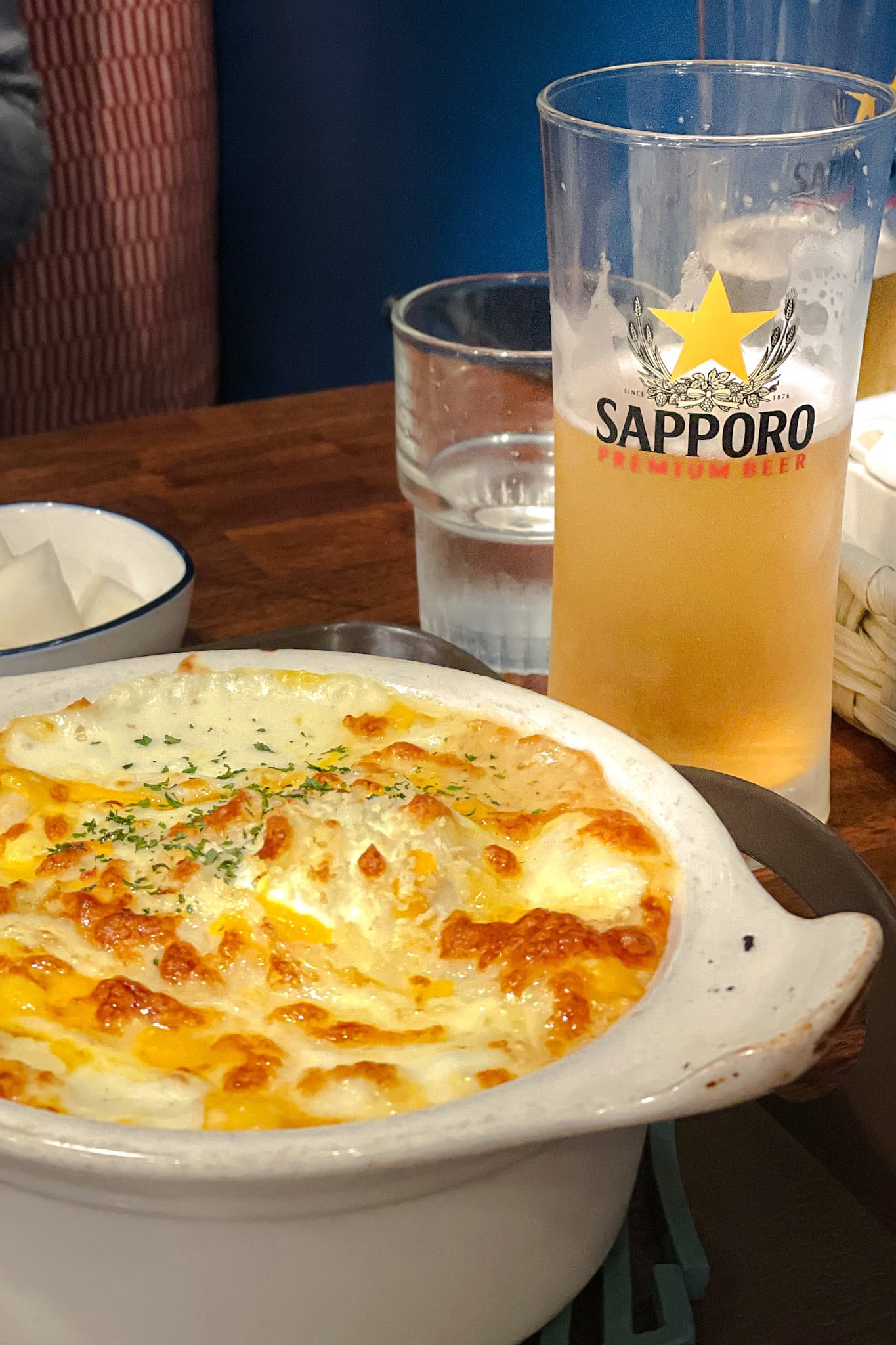 Gratin topped with melted cheese and a glass of Sapporo Beer