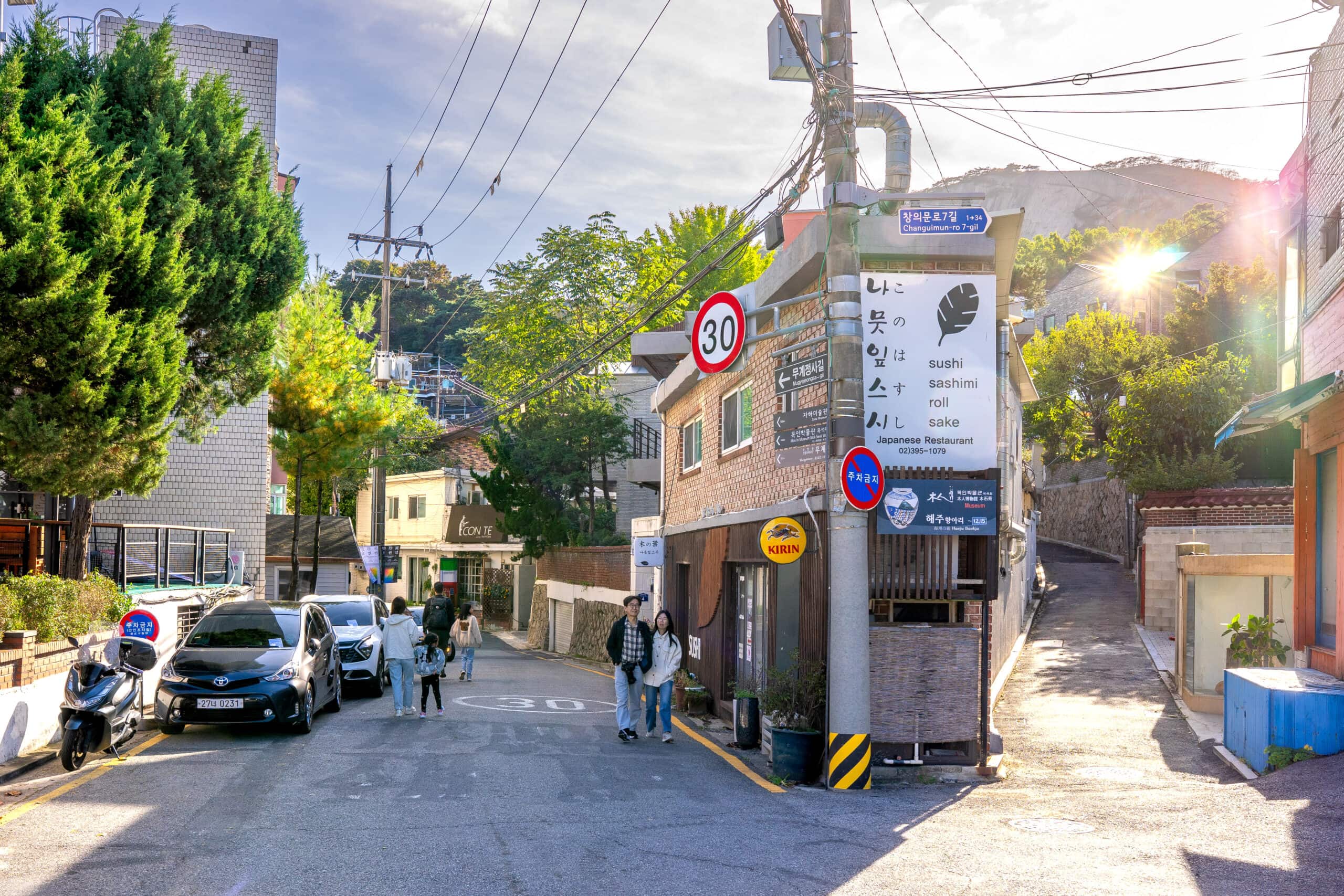 A sun-drenched street highlighting things to do in Buam-dong including local restaurants and scenic walking paths near Inwangsan
