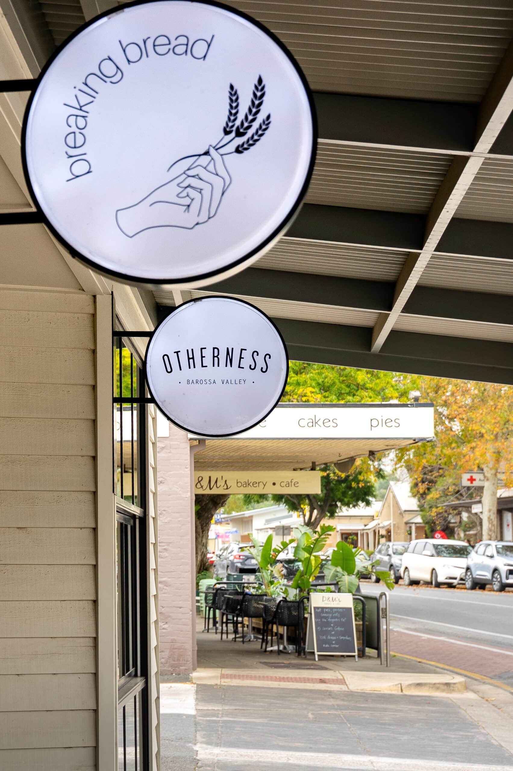Two white round signs to Breaking Bread and Otherness, both popular eateries in Angaston. You can see another cafe in the background