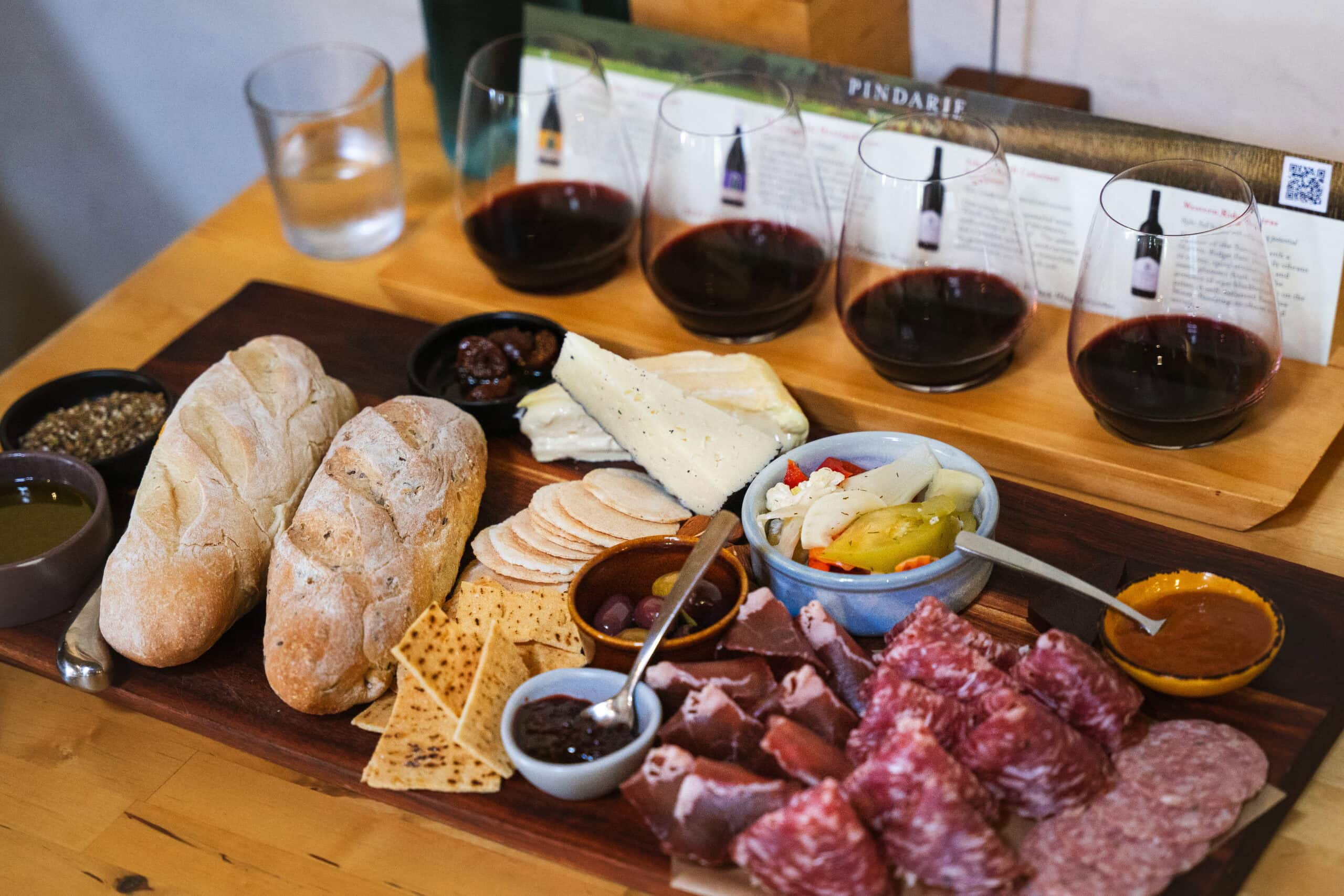 The Sharing Board with meats, cheeses, bread, olives, pickles, dried figs and crackers we had with four glasses of red wine for lunch at Pindarie Wines in gthe Barossa Valley