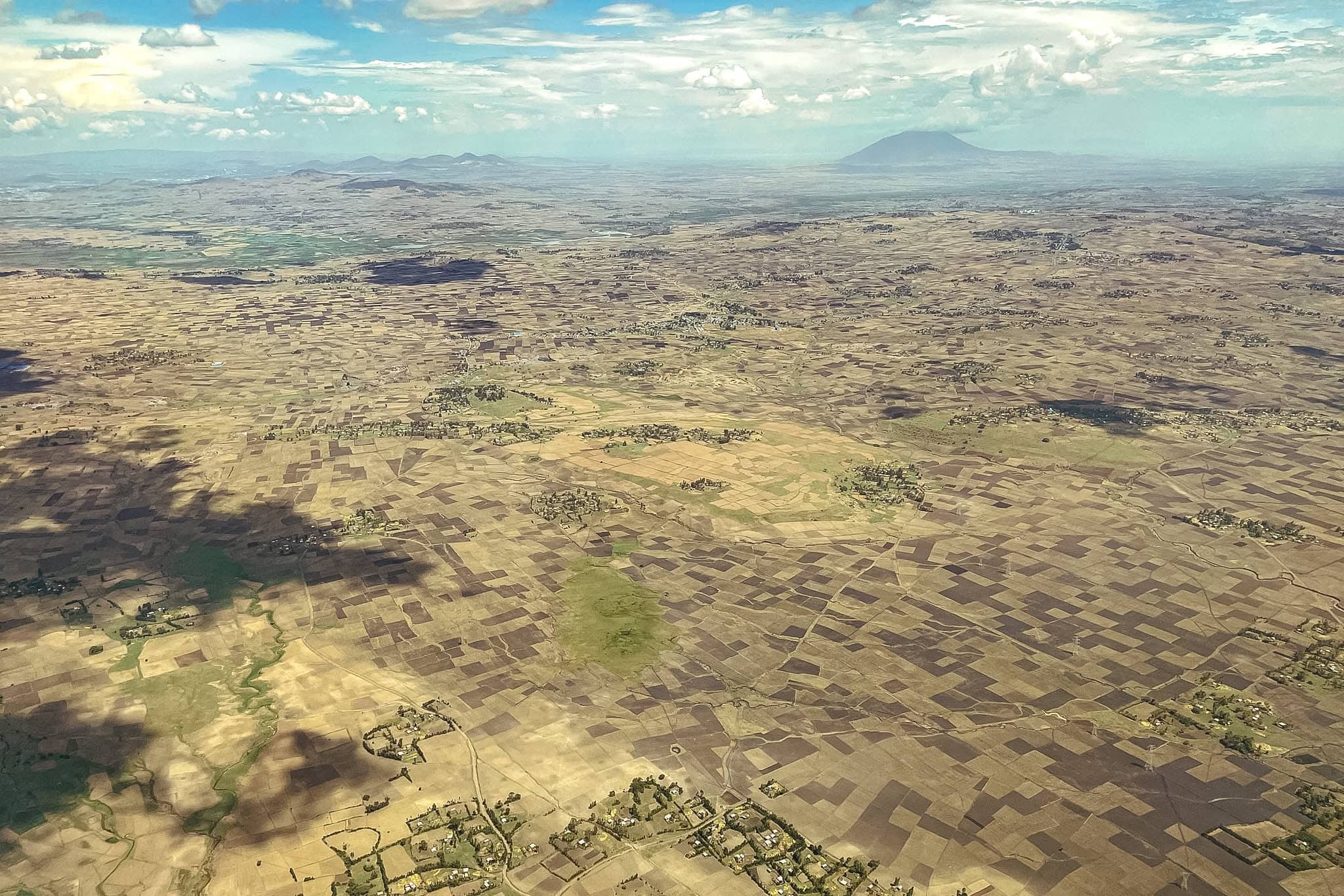 The view from the window as we approached Addis Ababa for landing. Its a landscape of the Ethiopian highlands with patched work fiels and hills on the horizon